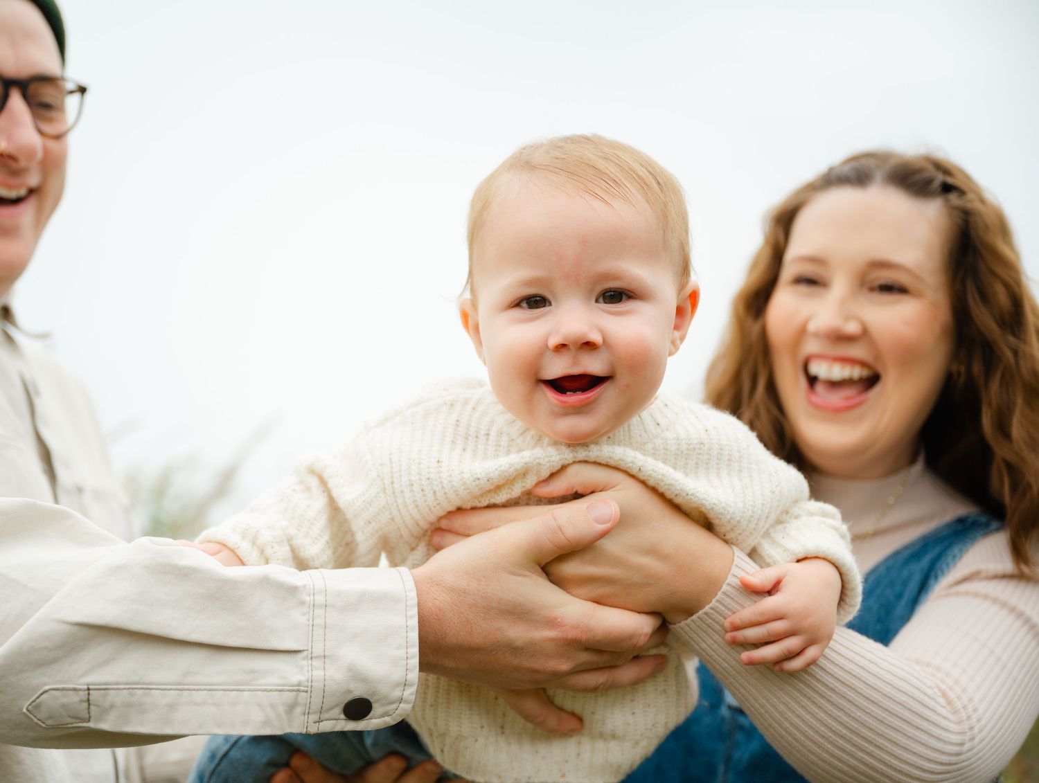 Candid family moment showing pure joy and laughter against bright background.