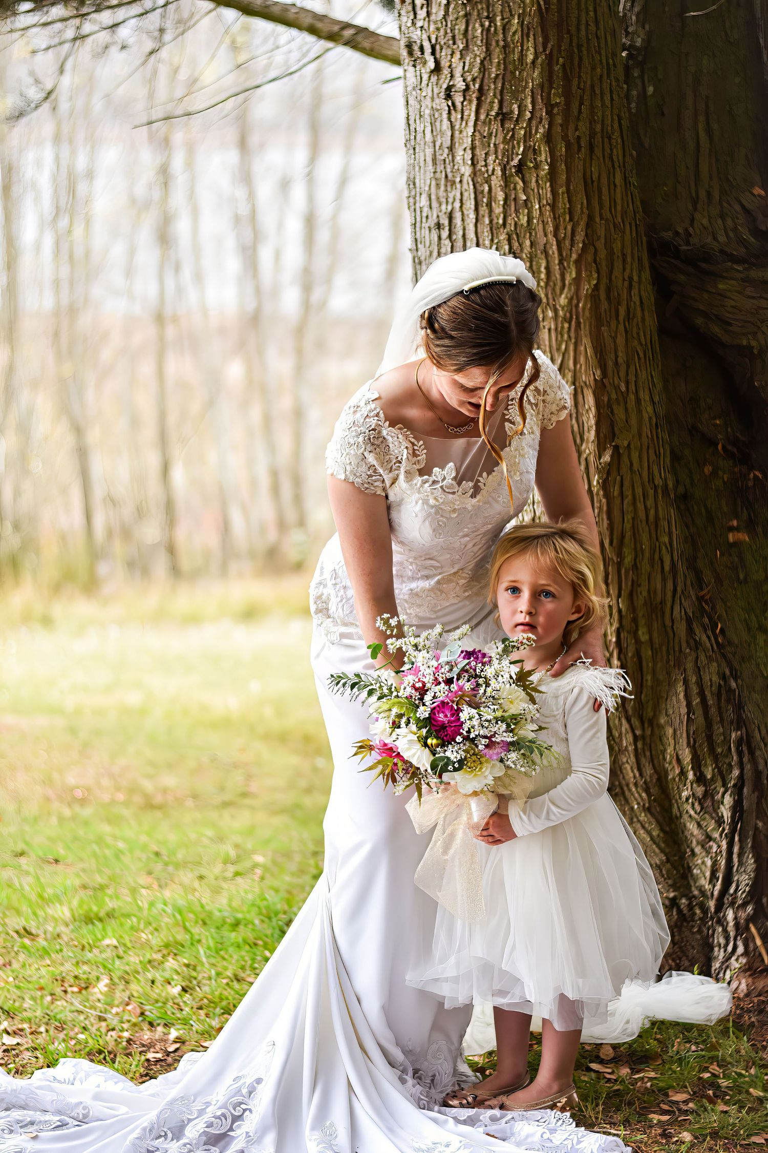 Wedding dress detail shot with floral bouquet in a natural outdoor setting.