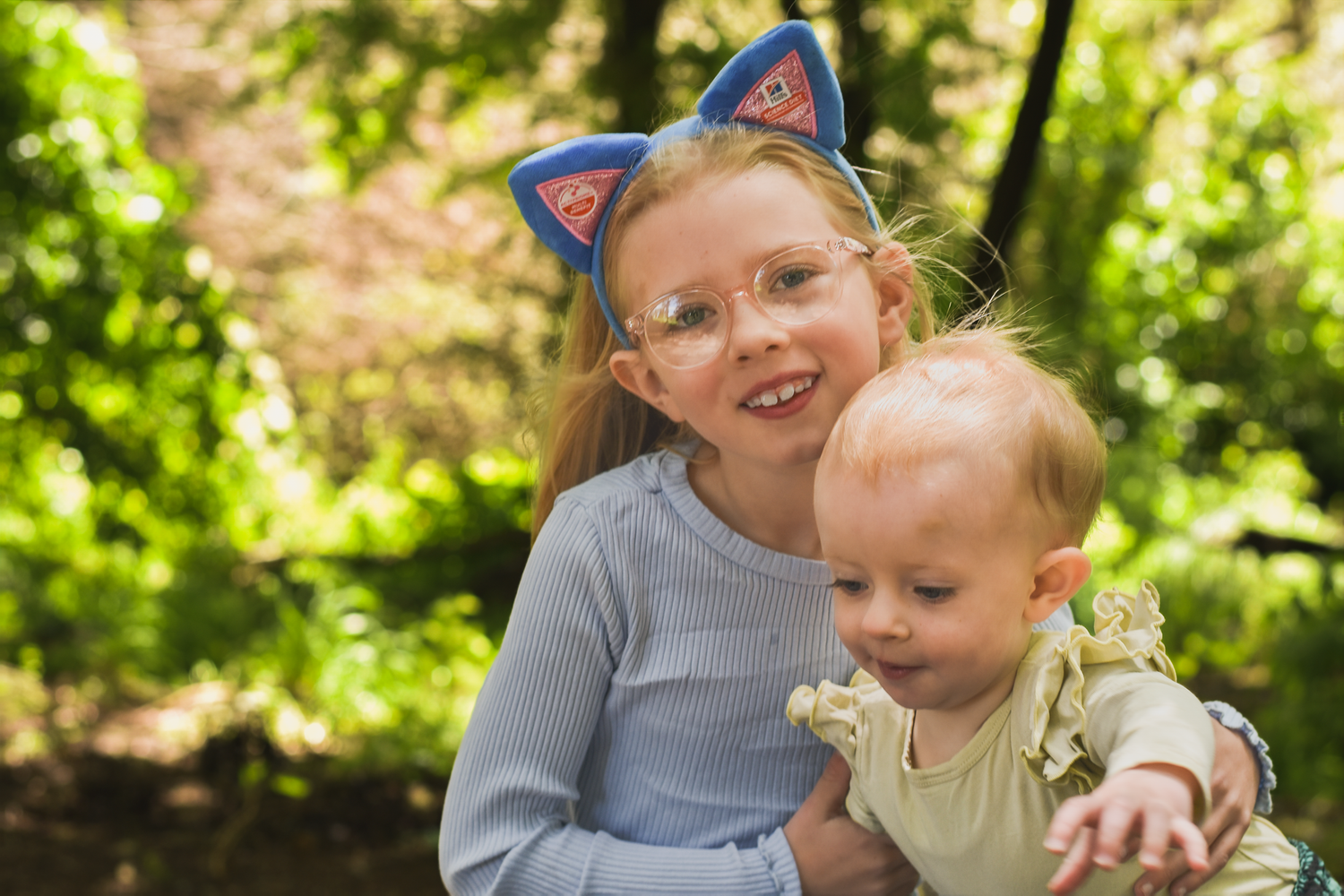 Family sharing joyful moments together in a sunny green forest setting.