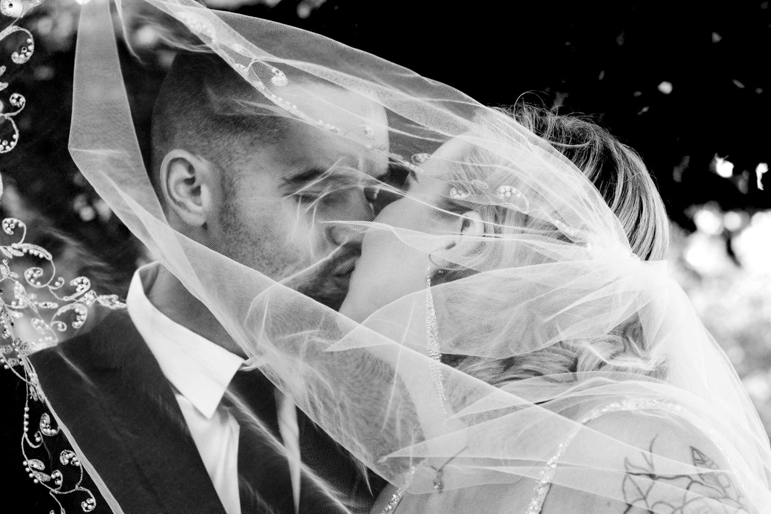 Wedding photograph with veil covering in black and white.