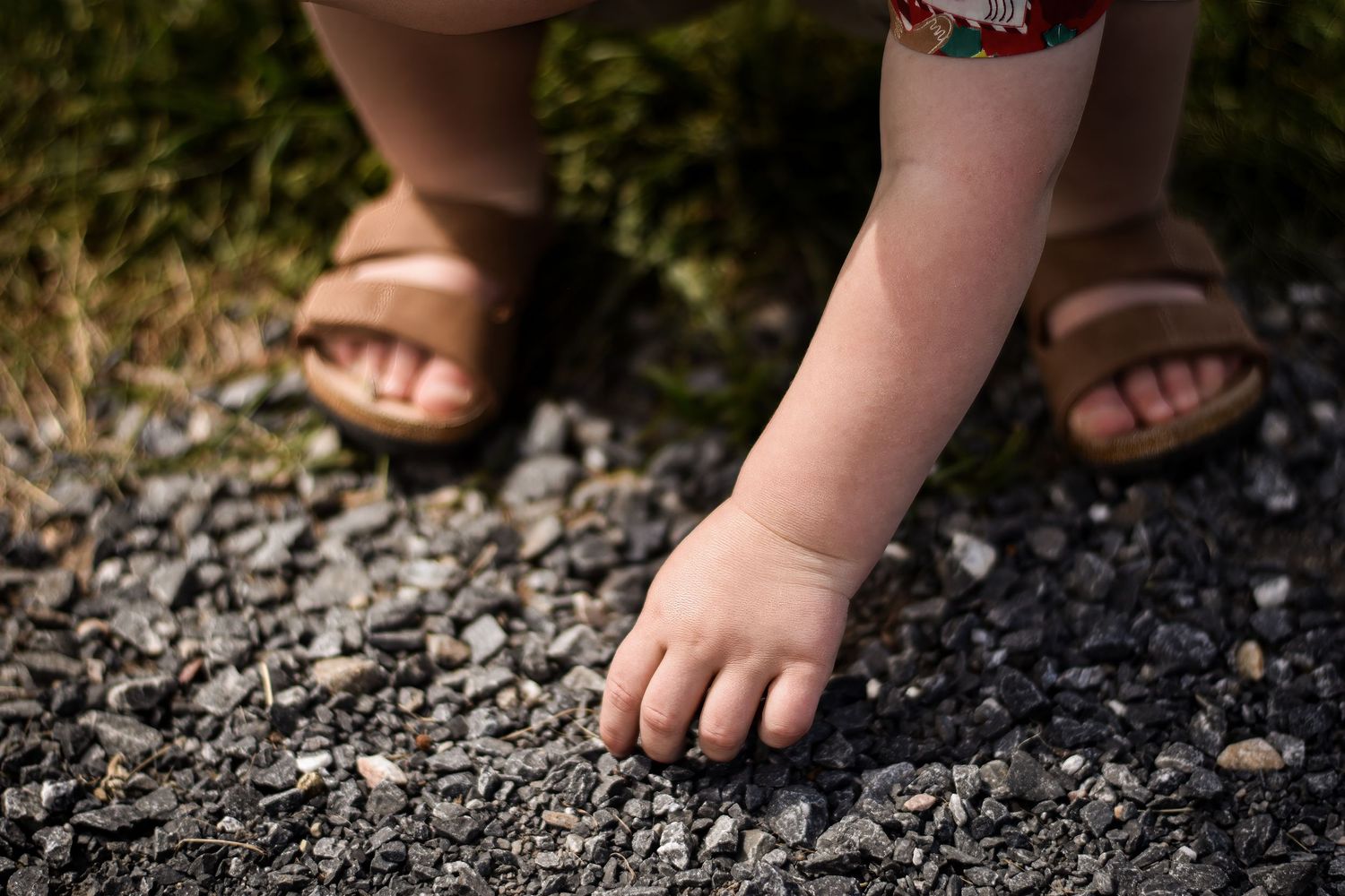 Close-up series of bare feet walking on gravel ground.