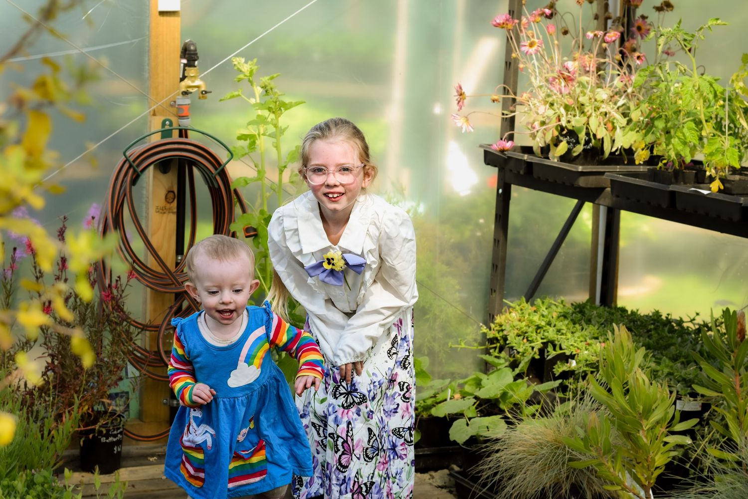 Children playing and exploring together in a lush garden setting.