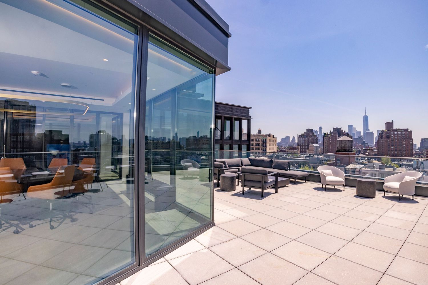 Luxury rooftop terrace with outdoor seating and panoramic New York City skyline views.