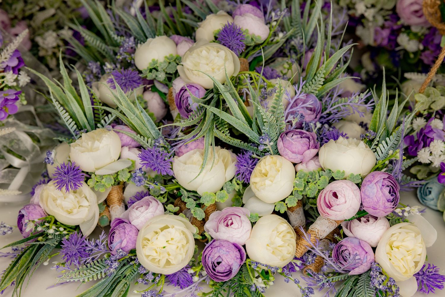 Beautiful wedding bouquets featuring white peonies and purple flowers with lush green foliage.