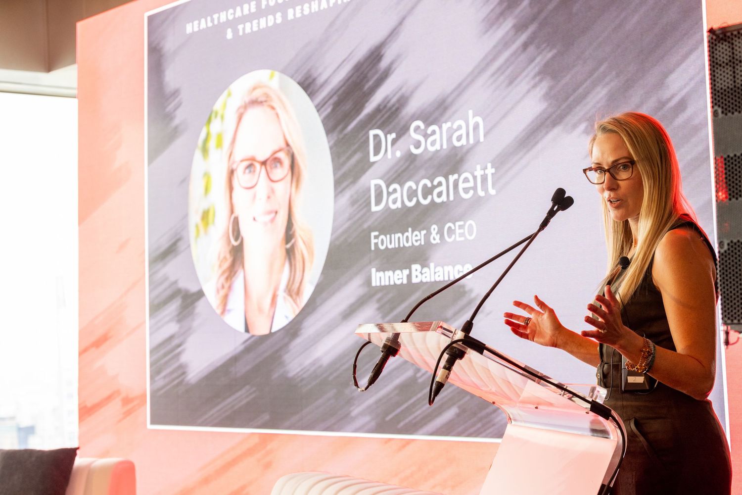 Dr. Sarah Daccarett, Founder and CEO of Inner Balance, presents at a healthcare conference podium.
