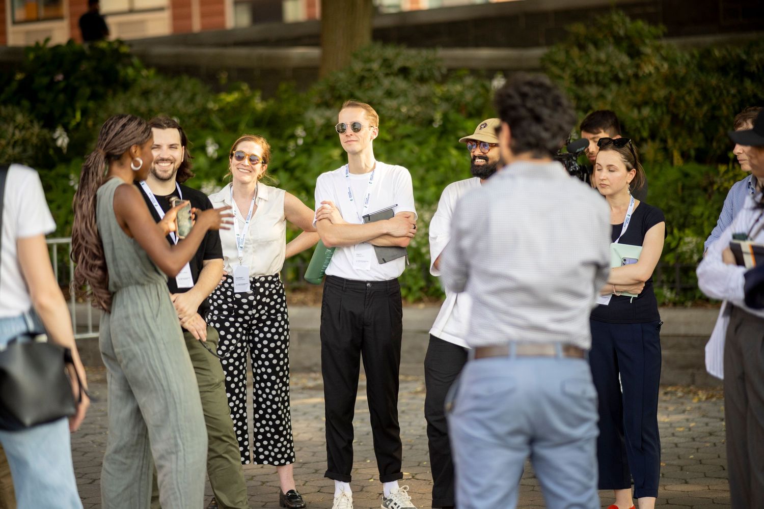 Small group of casually dressed professionals engaged in outdoor networking conversation.