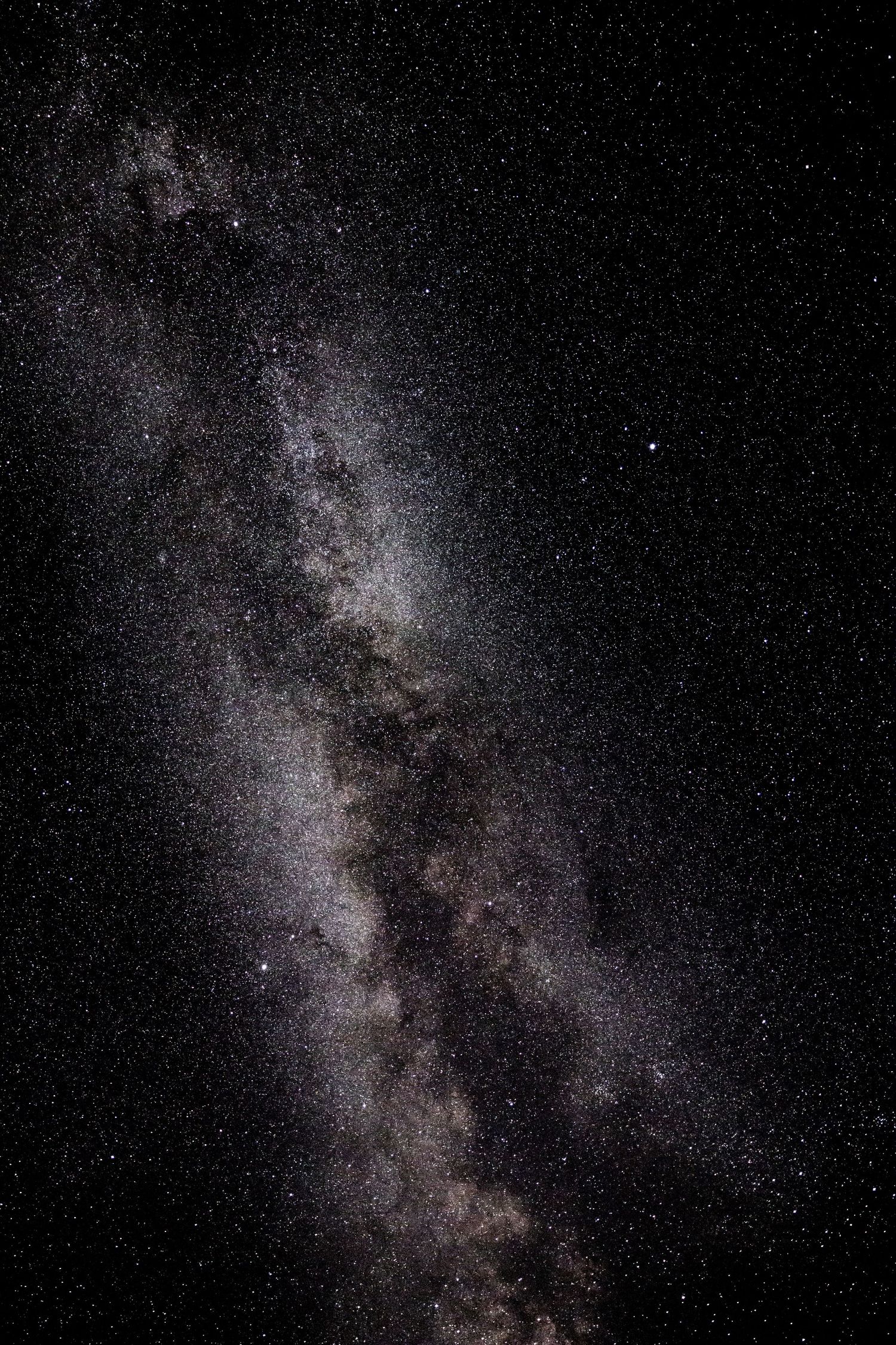 Astrophotography of the Milky Way galaxy stretching across a dark night sky.