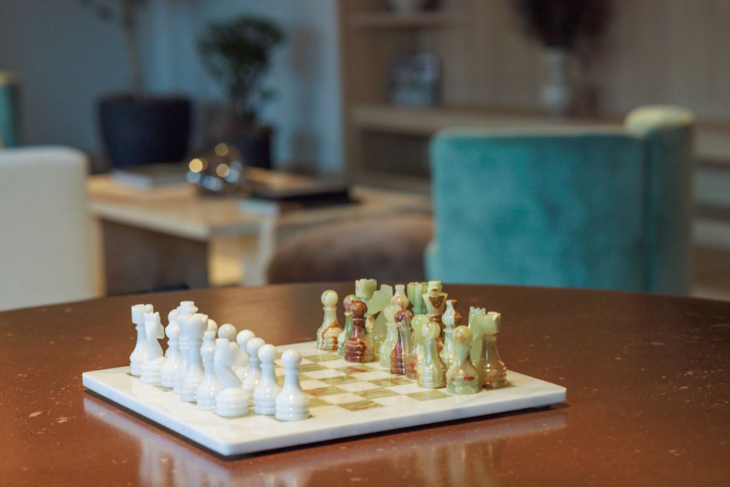 Elegant marble chess set displayed on a polished wooden table in a stylish modern living room.