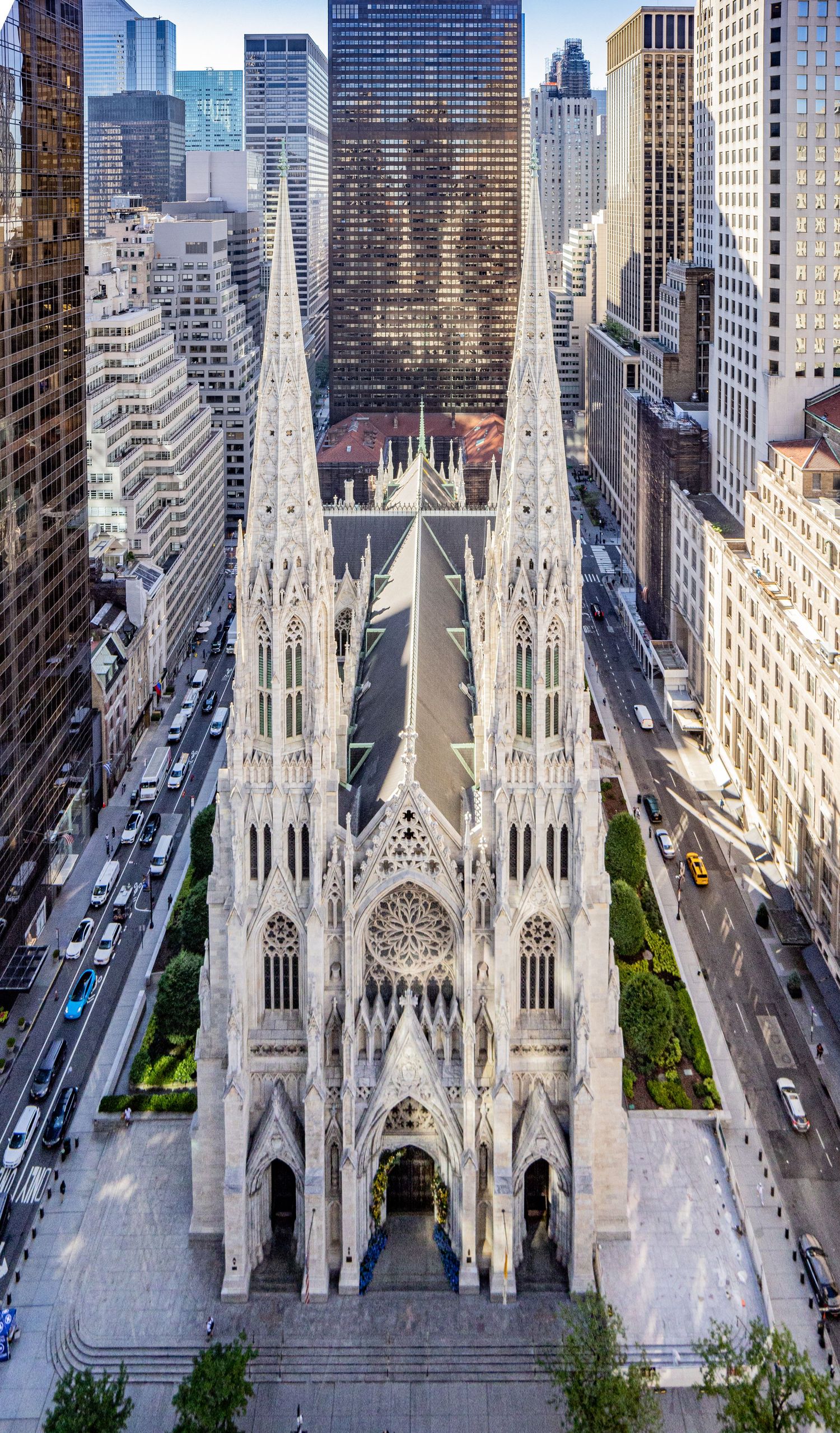 Aerial view of St. Patricks Cathedral Gothic architecture surrounded by Manhattan skyscrapers in New York City.