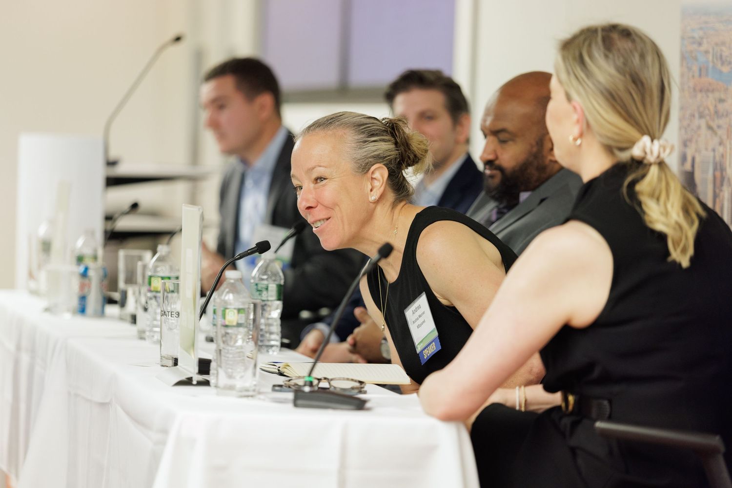 Panel of business professionals seated at a conference table during a corporate discussion or forum event.