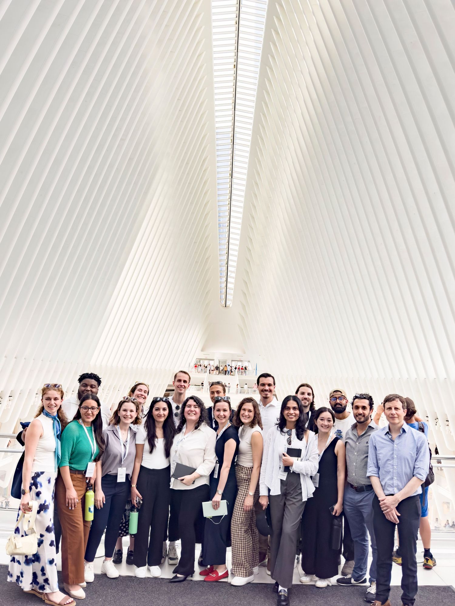 Group of diverse professionals posing inside the iconic white Oculus at World Trade Center NYC.