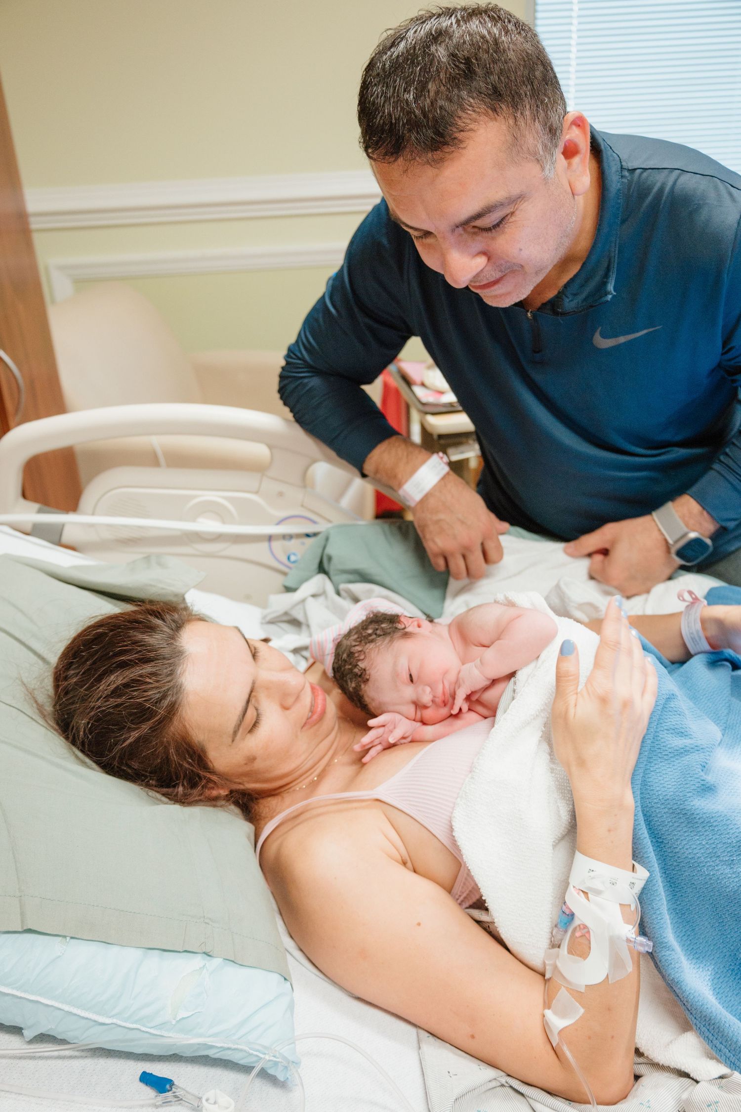 Medical staff attending to a patient during labor and delivery in a hospital room.