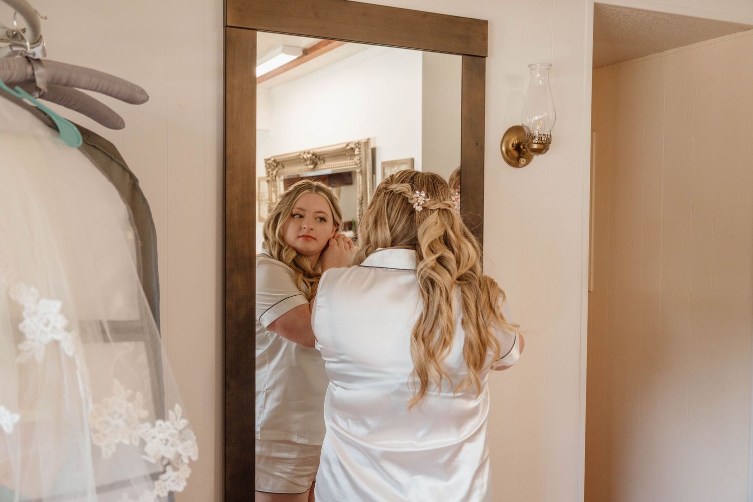 Wedding dress being fitted and adjusted in a dressing room.
