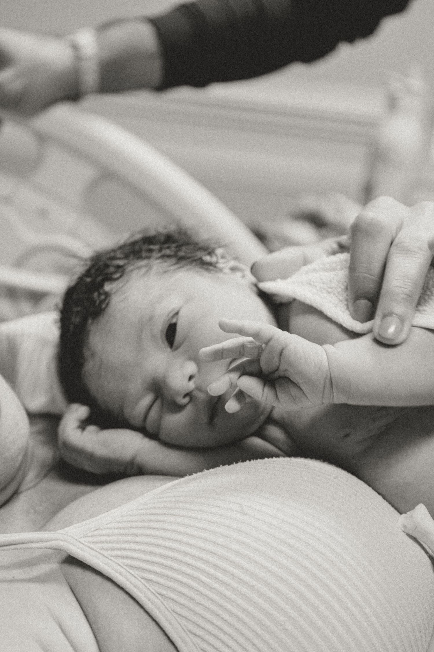 Black and white photos showing a newborn baby receiving medical care.