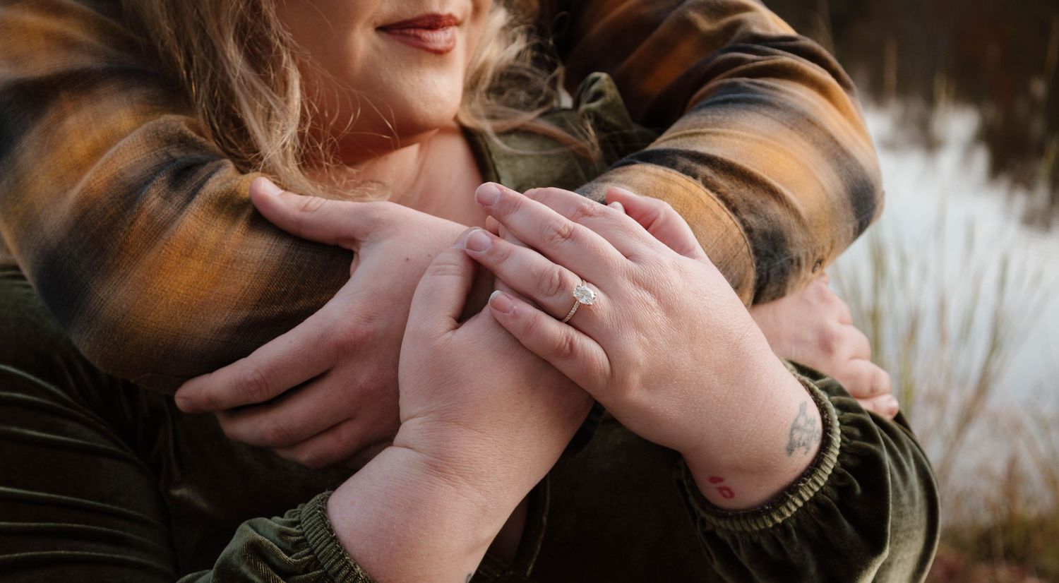 Close-up of hands showing engagement ring detail.