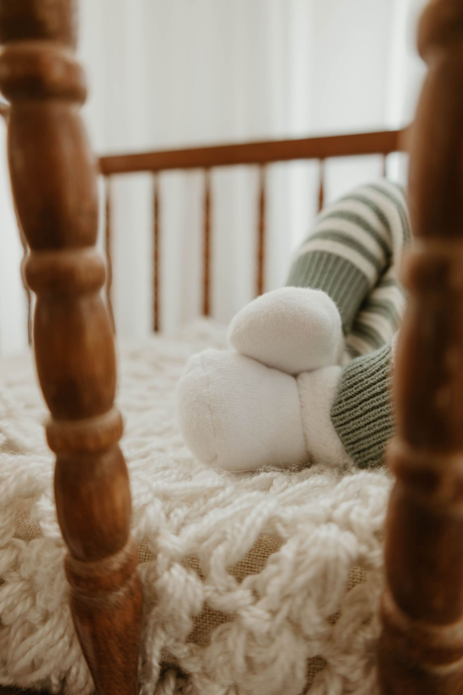 The image shows a cozy, rustic-style bed frame with soft, fluffy white bedding and pillows, creating a warm and inviting atmosphere.