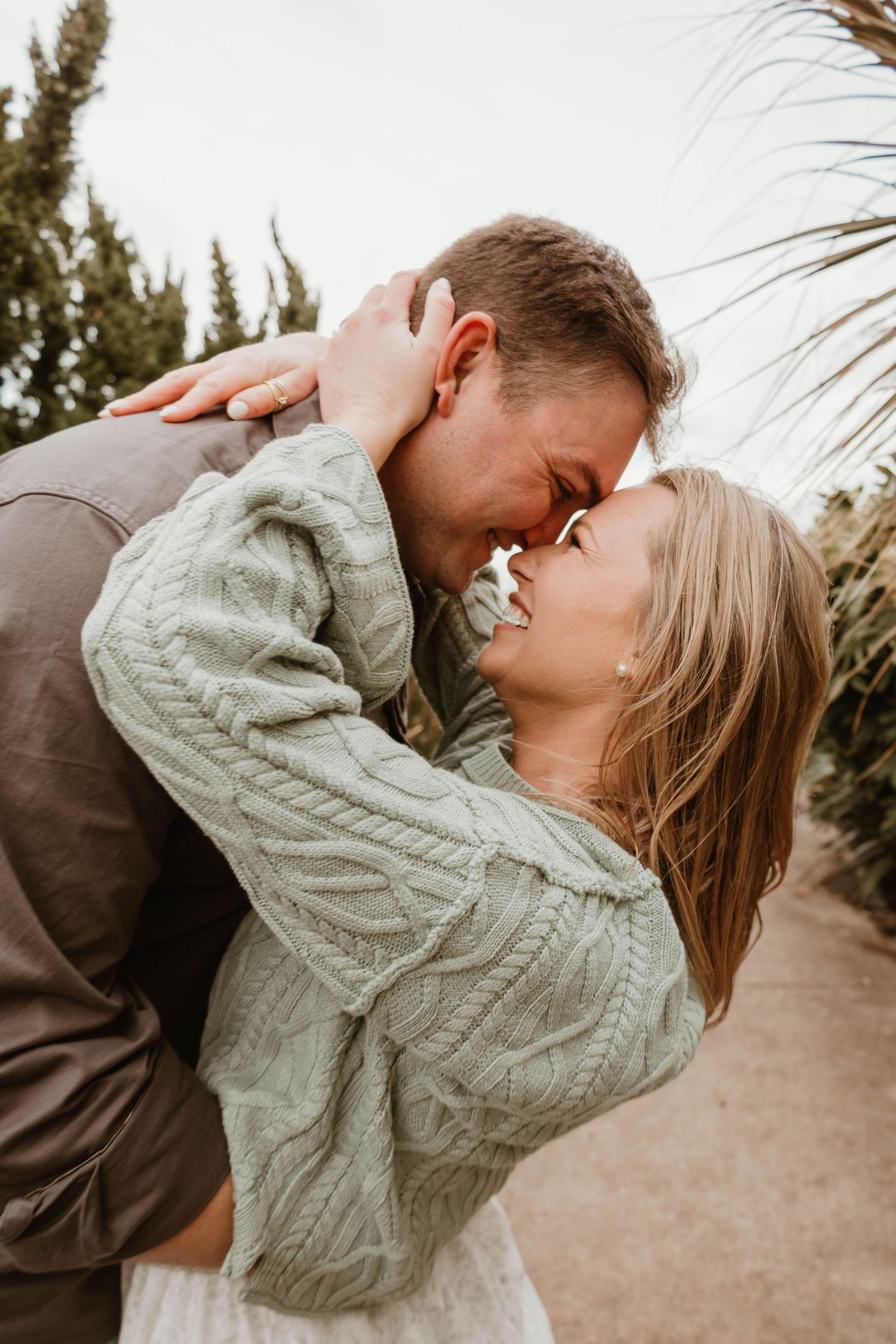 A romantic couple embraces and shares intimate moments in a series of candid outdoor photos at sunset.