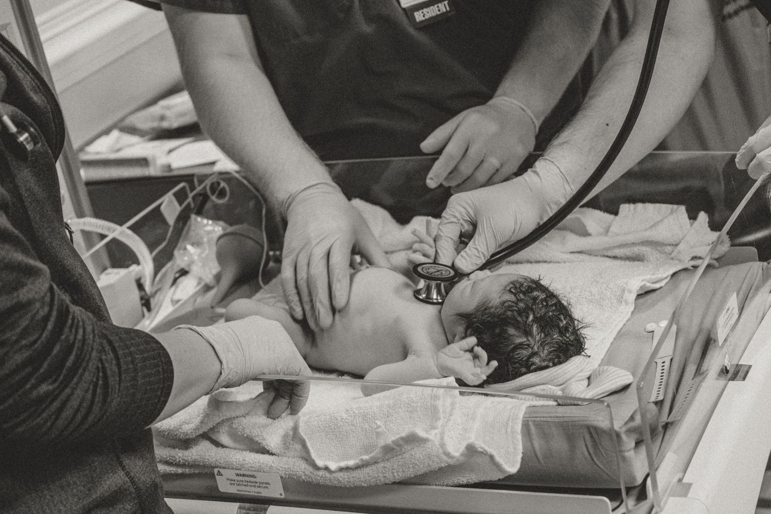 Medical staff attending to newborn baby in hospital setting.