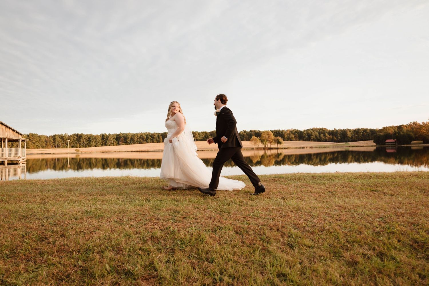 Couple walking along a scenic path during their autumn wedding celebration.