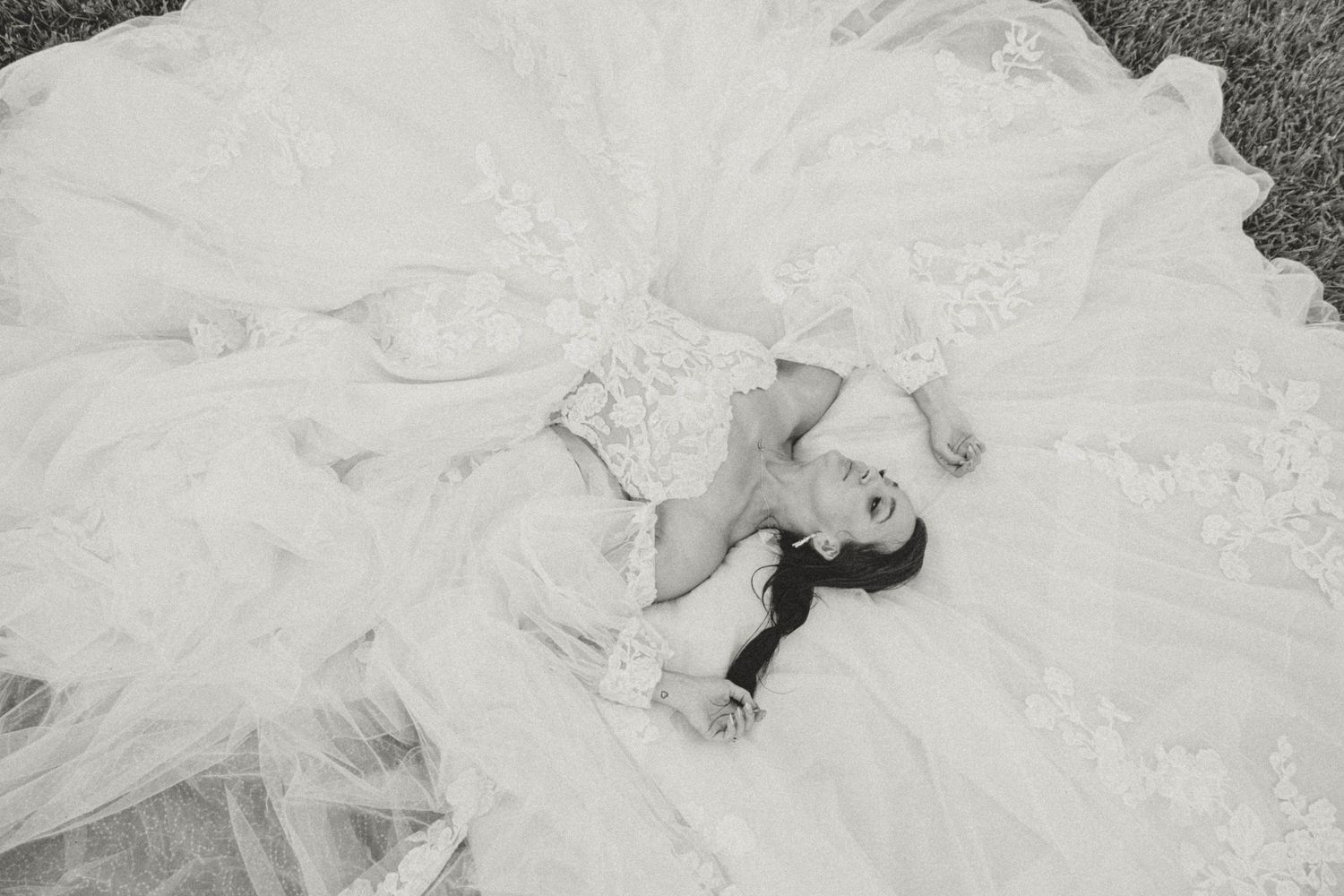 Aerial view of a bride in white dress creating dramatic angles on grass.
