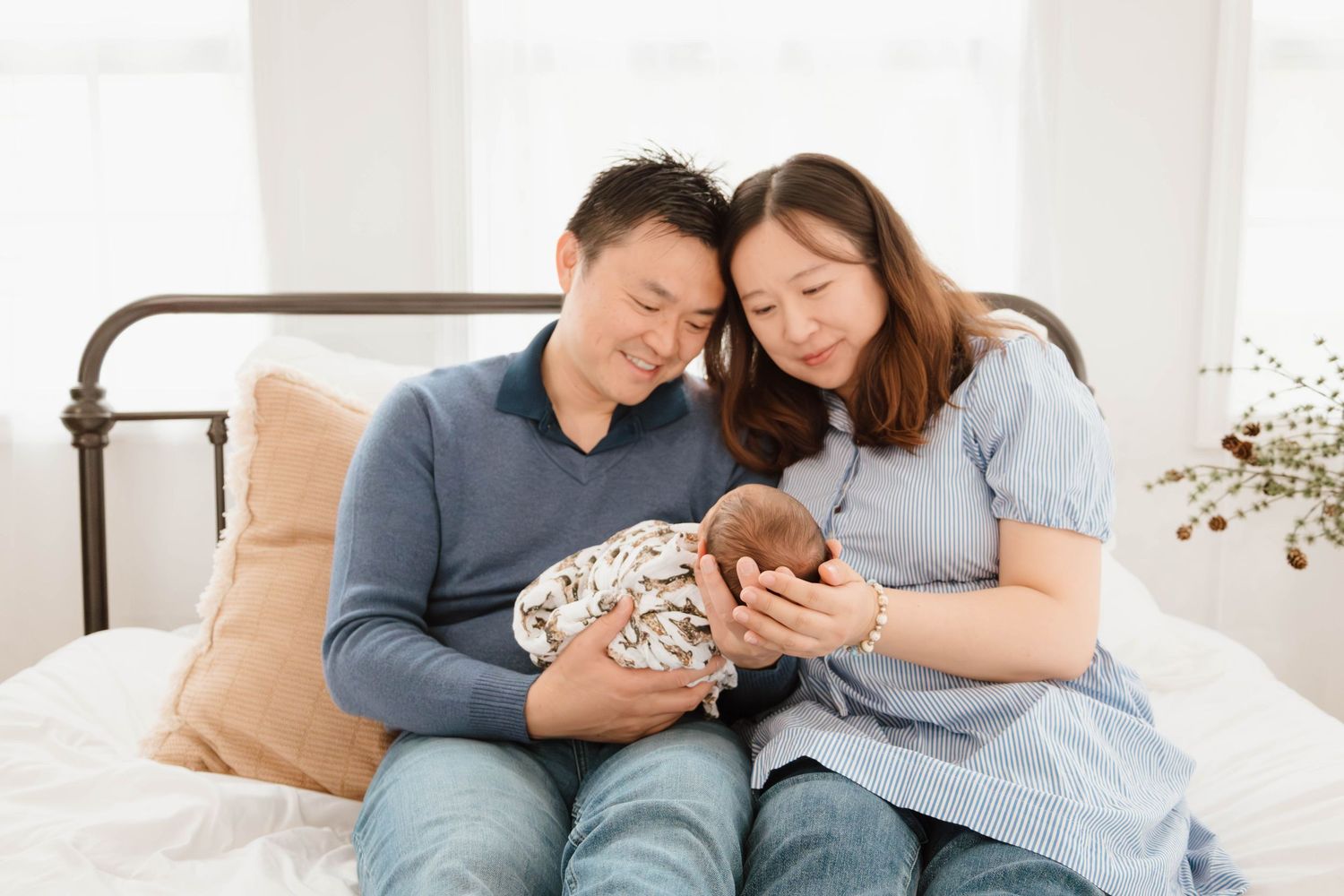 Family lounging together on floor while bonding with their newborn baby.