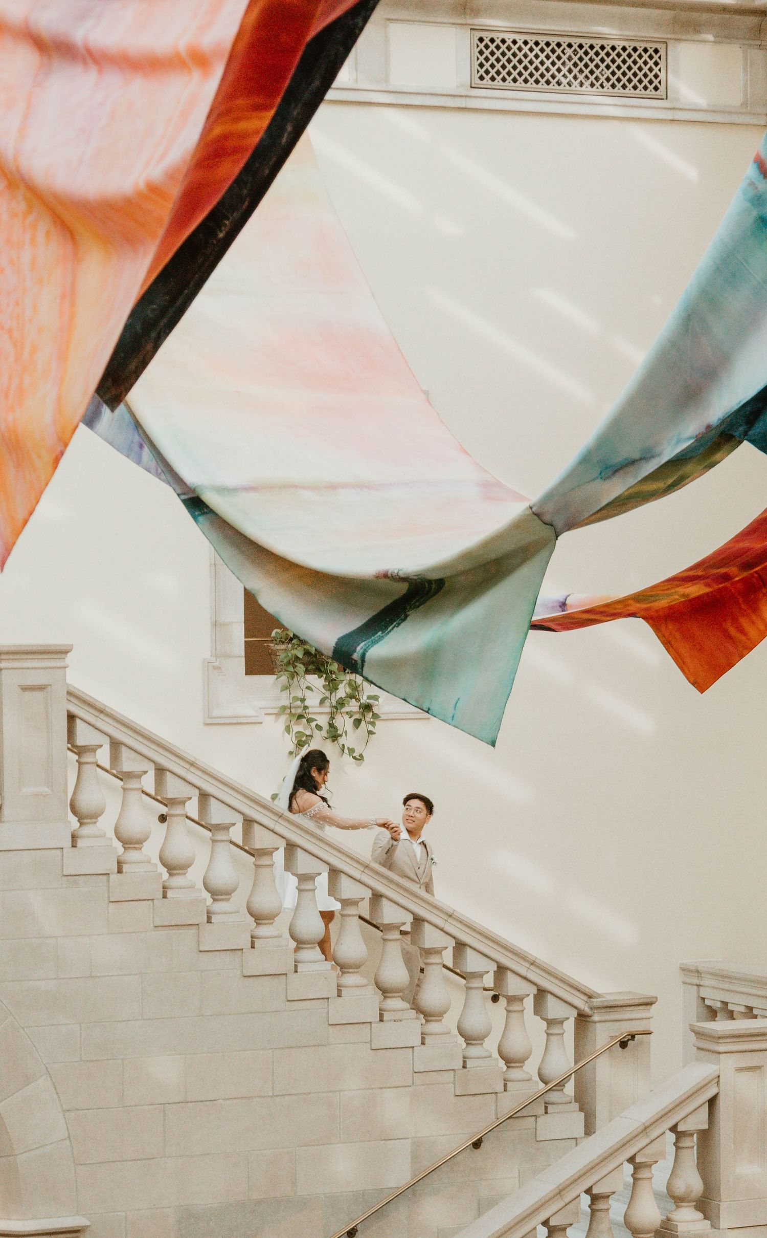 A colorful abstract art installation with flowing fabric shapes is displayed in an interior setting.