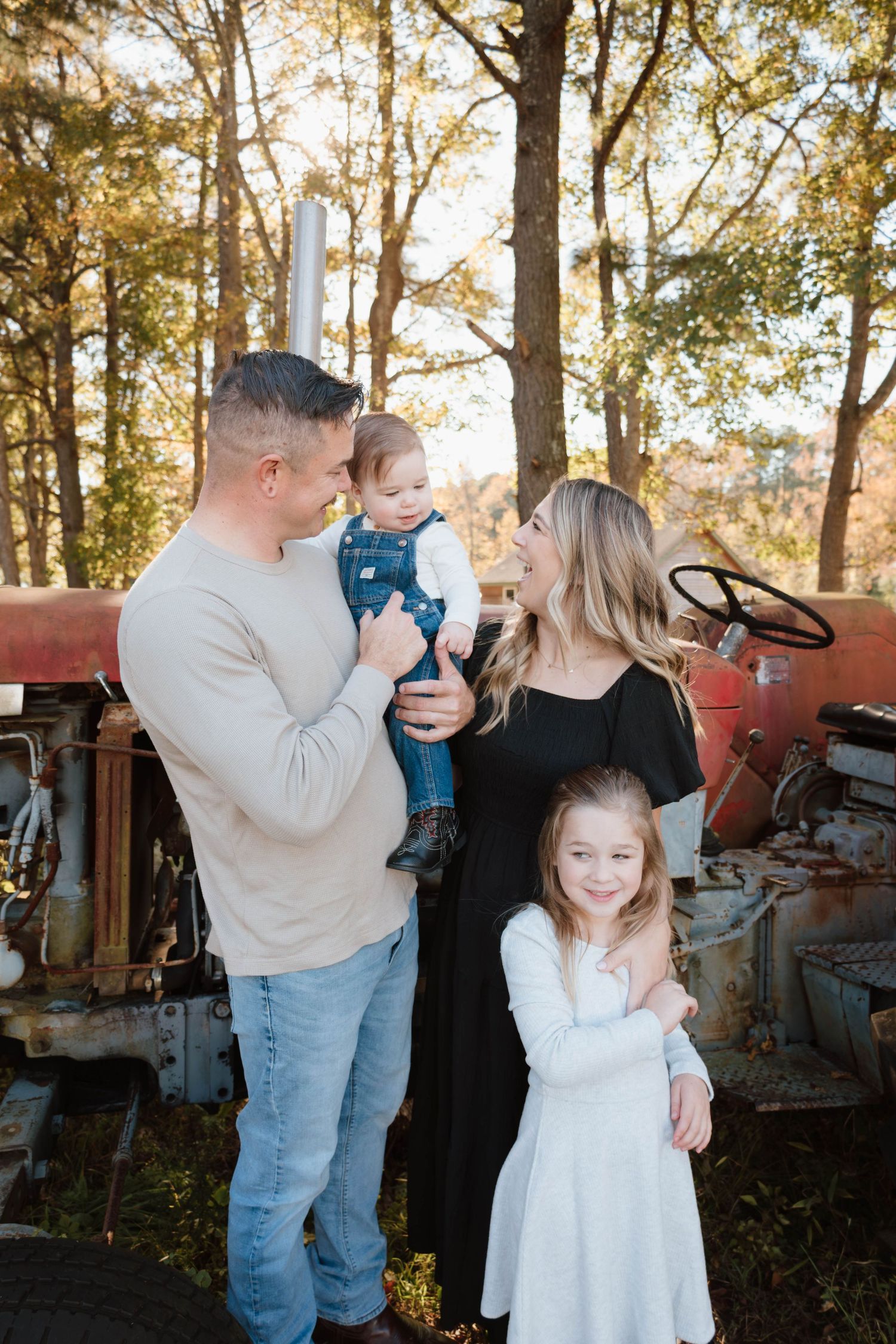 Family gathering near vintage tractors during a golden autumn afternoon.