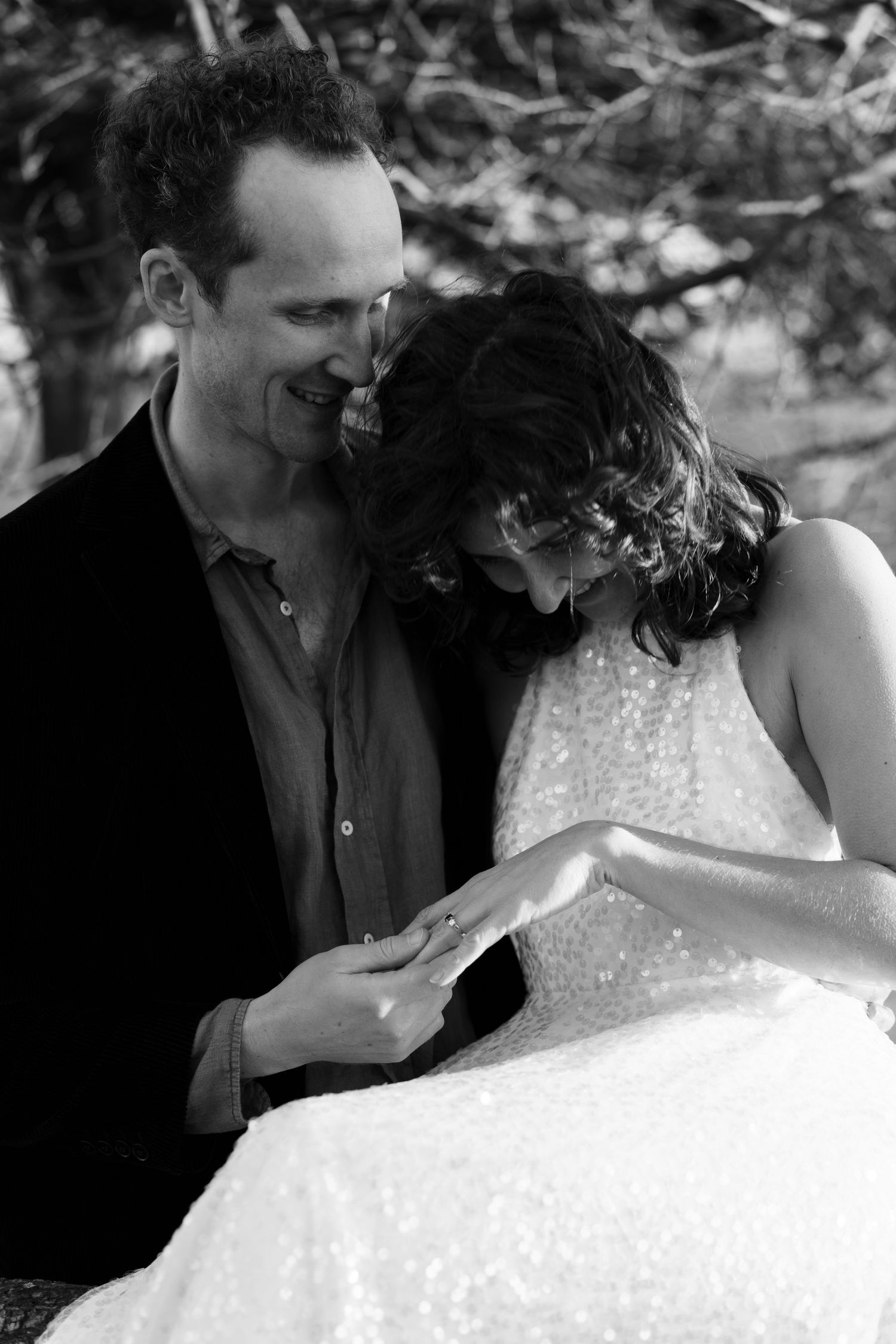 Intimate black and white portrait of couple laughing together outdoors.