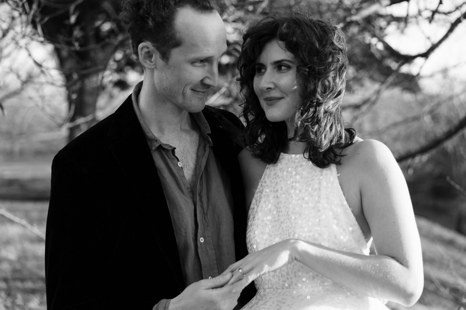 A romantic wedding photo series showing a couple embracing outdoors in black and white.