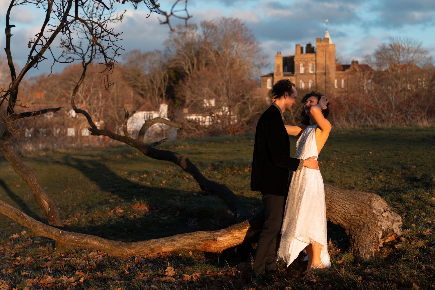 A romantic outdoor photoshoot with dramatic lighting and urban architecture in the background.