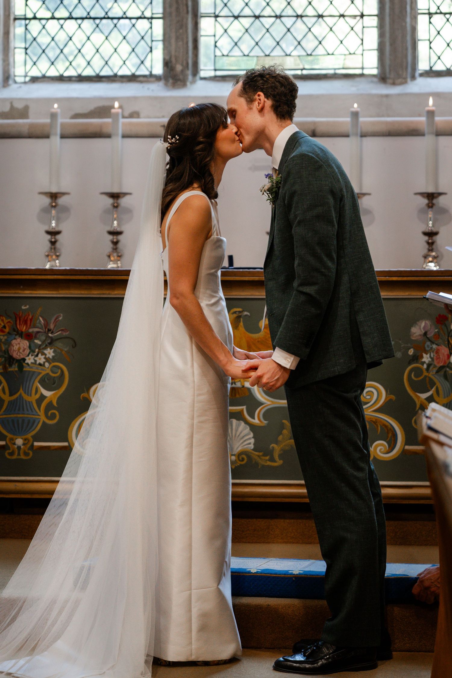 Bride and groom share their first kiss at the altar during a church wedding ceremony.