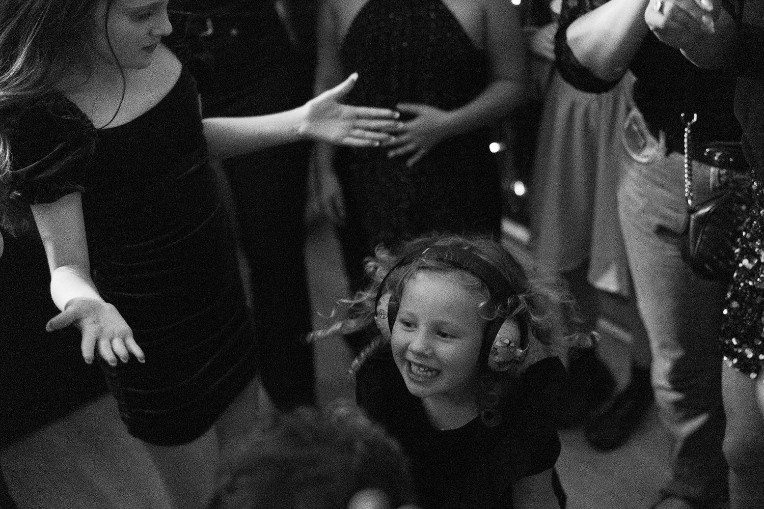 Monochrome candid moment captured at a party with festive lighting.