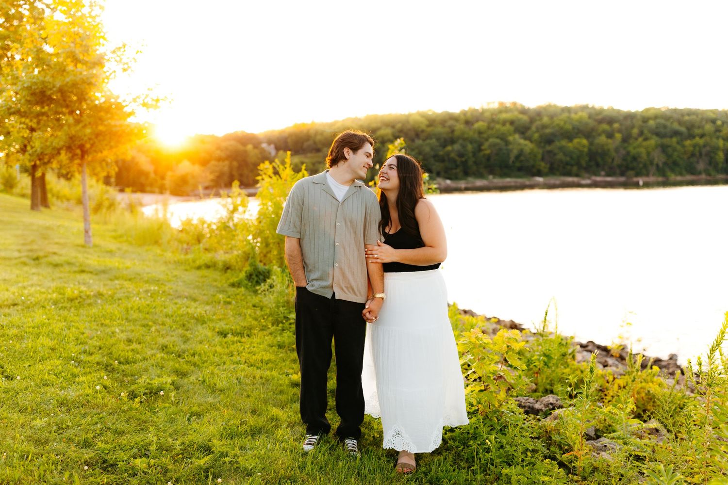 Golden sunset light illuminates a scenic waterfront landscape.
