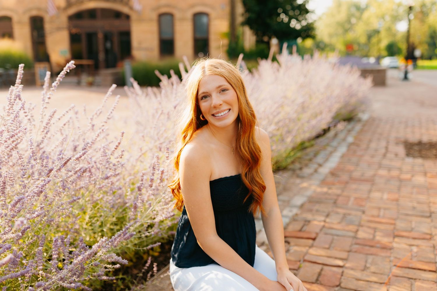 Senior portraits among blooming lavender plants and brick pathways.