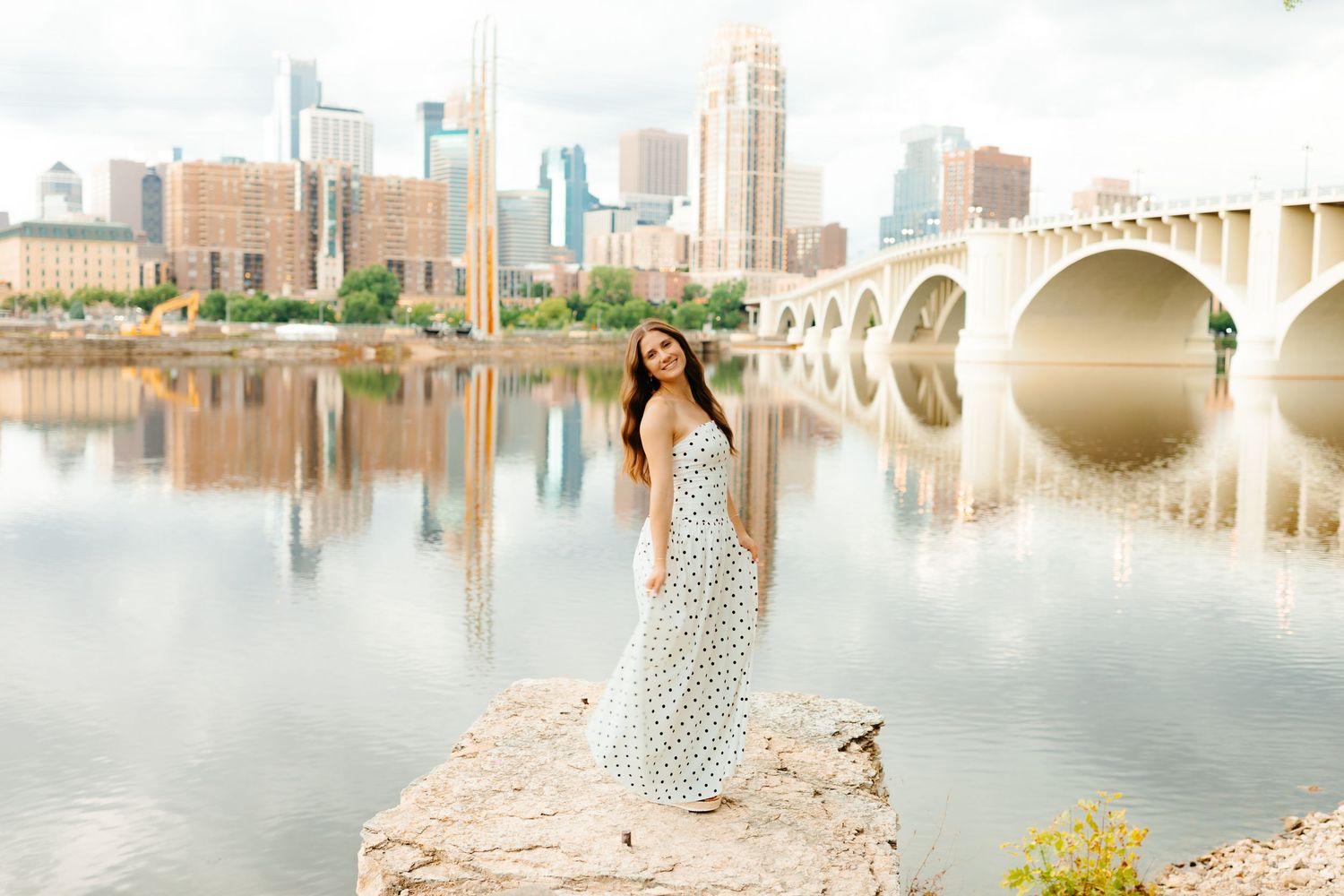 City skyline reflecting in calm water with architectural elements in foreground.