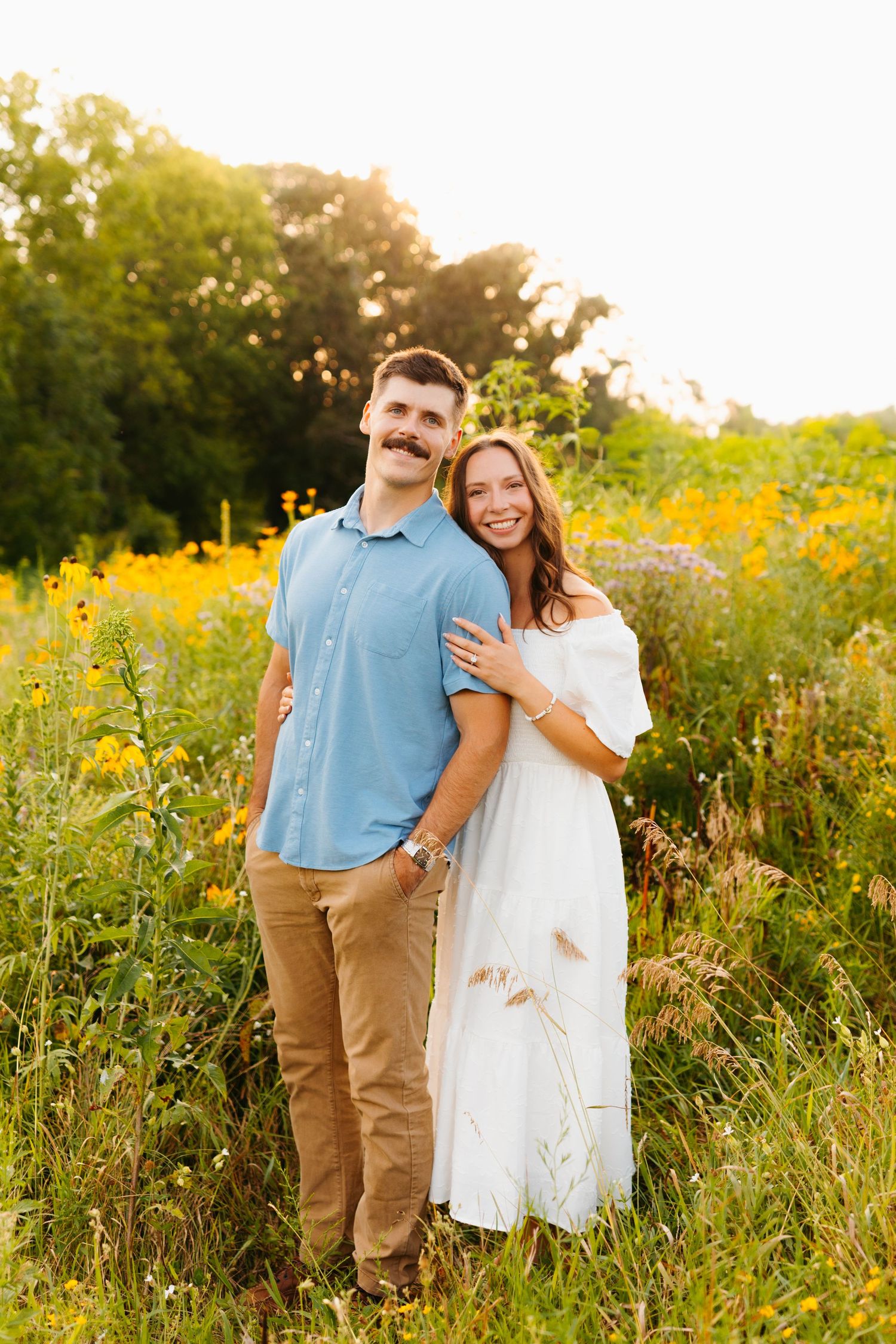 Couple shares tender moments in a wildflower field during golden hour.