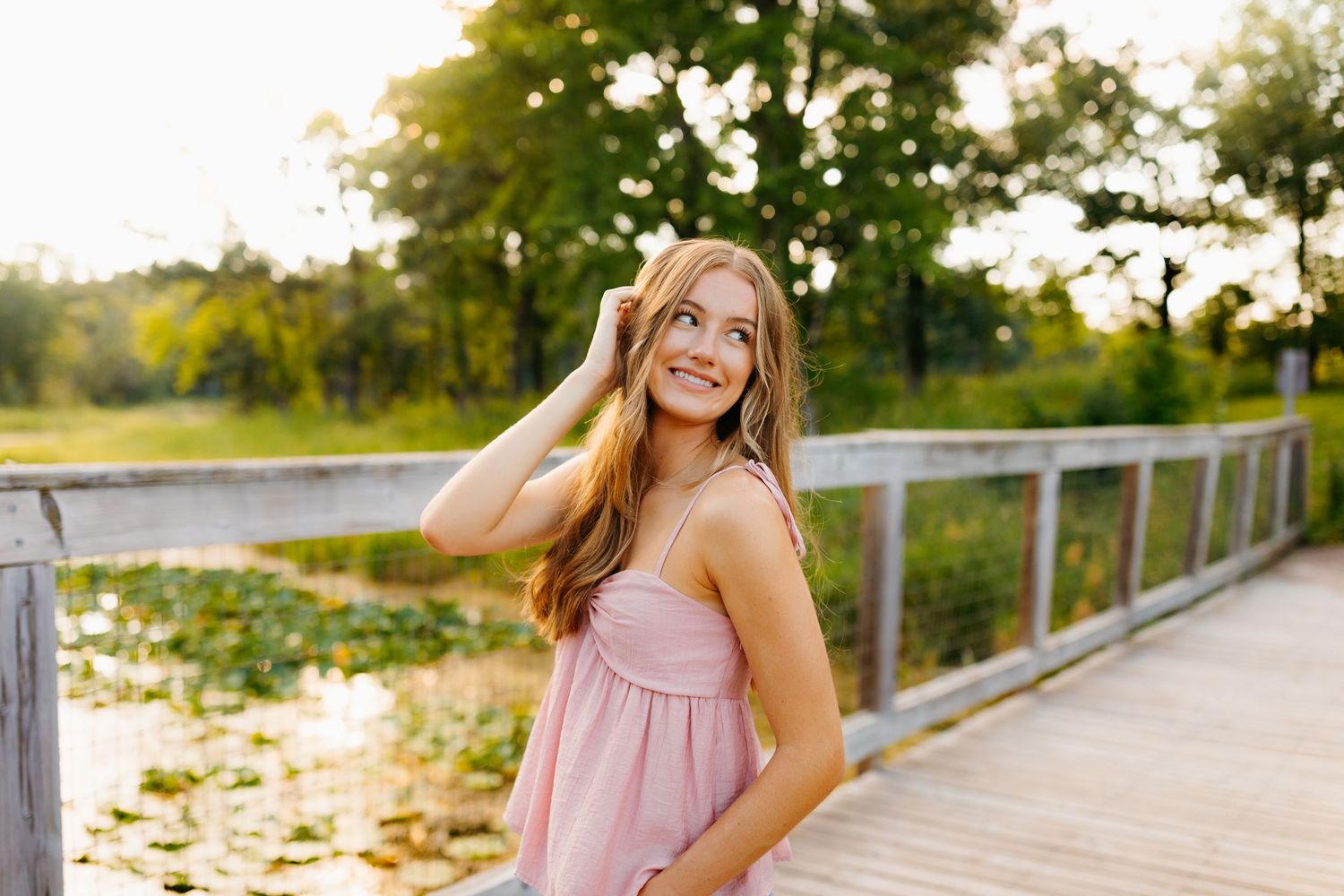 Outdoor portrait session on a wooden boardwalk during golden hour.