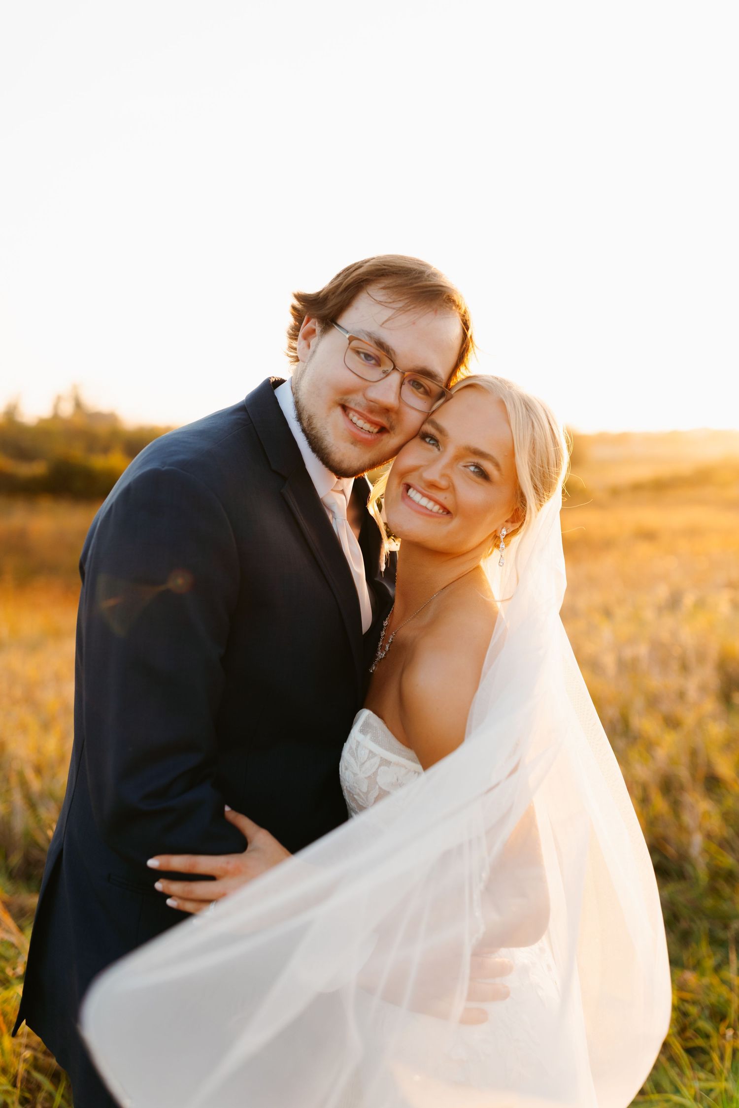Intimate wedding portraits captured in warm sunset light against natural landscape.