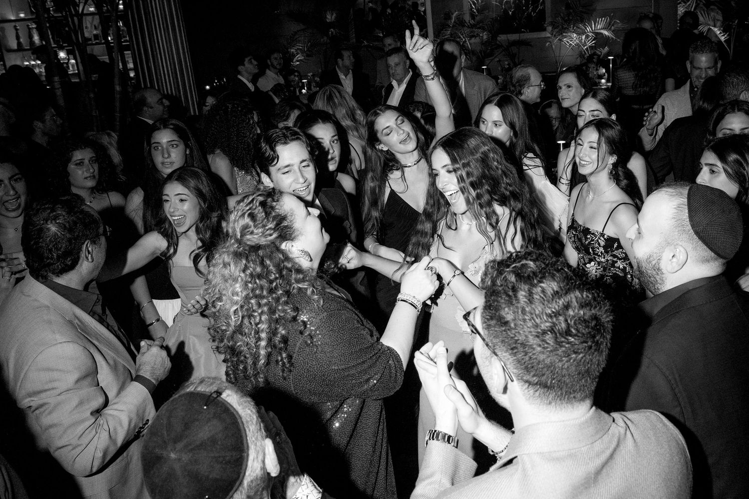 Lively black and white photo of guests dancing at a glamorous evening party.