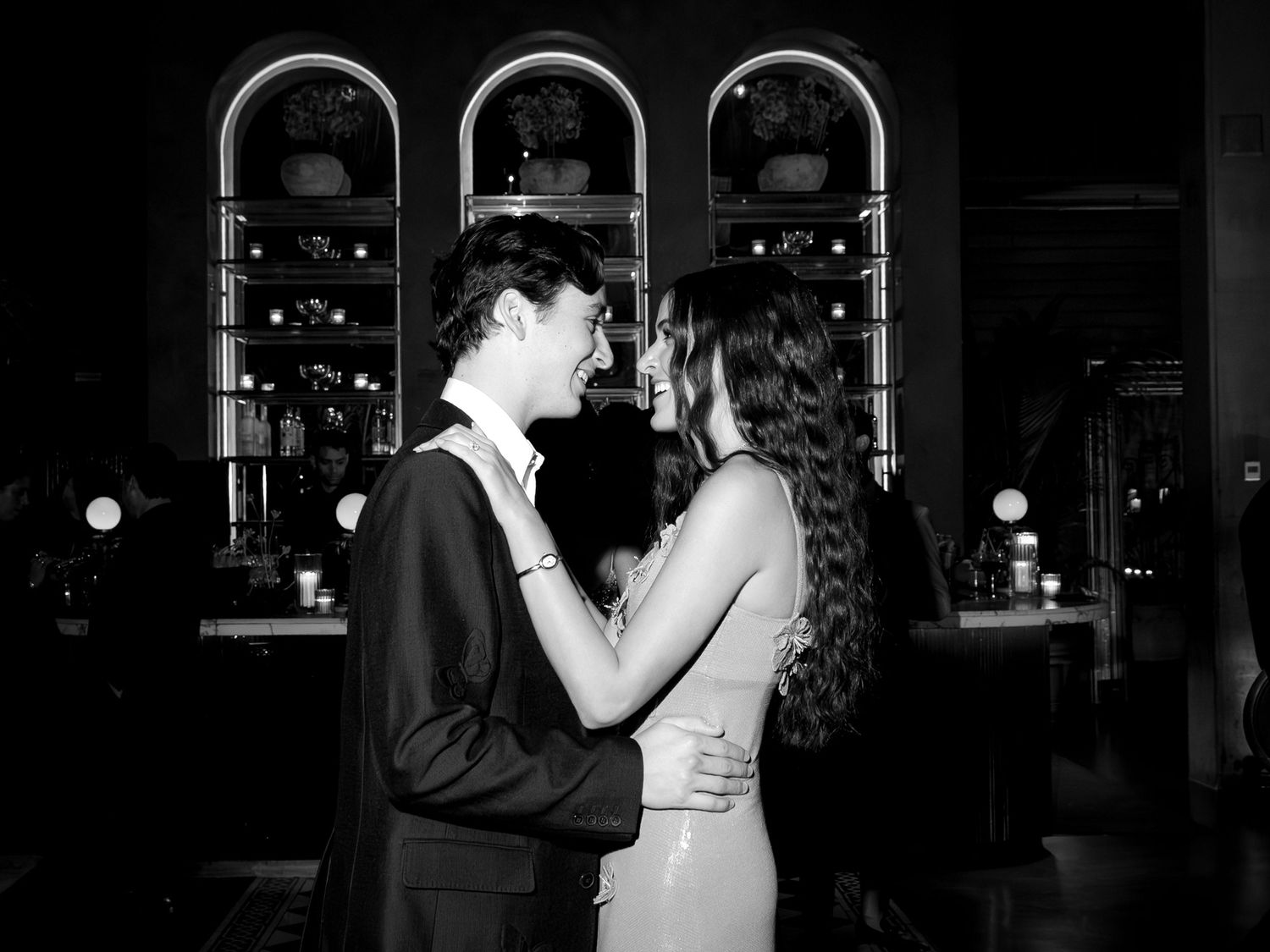 Black and white romantic photo of a couple gazing at each other in an elegant bar.