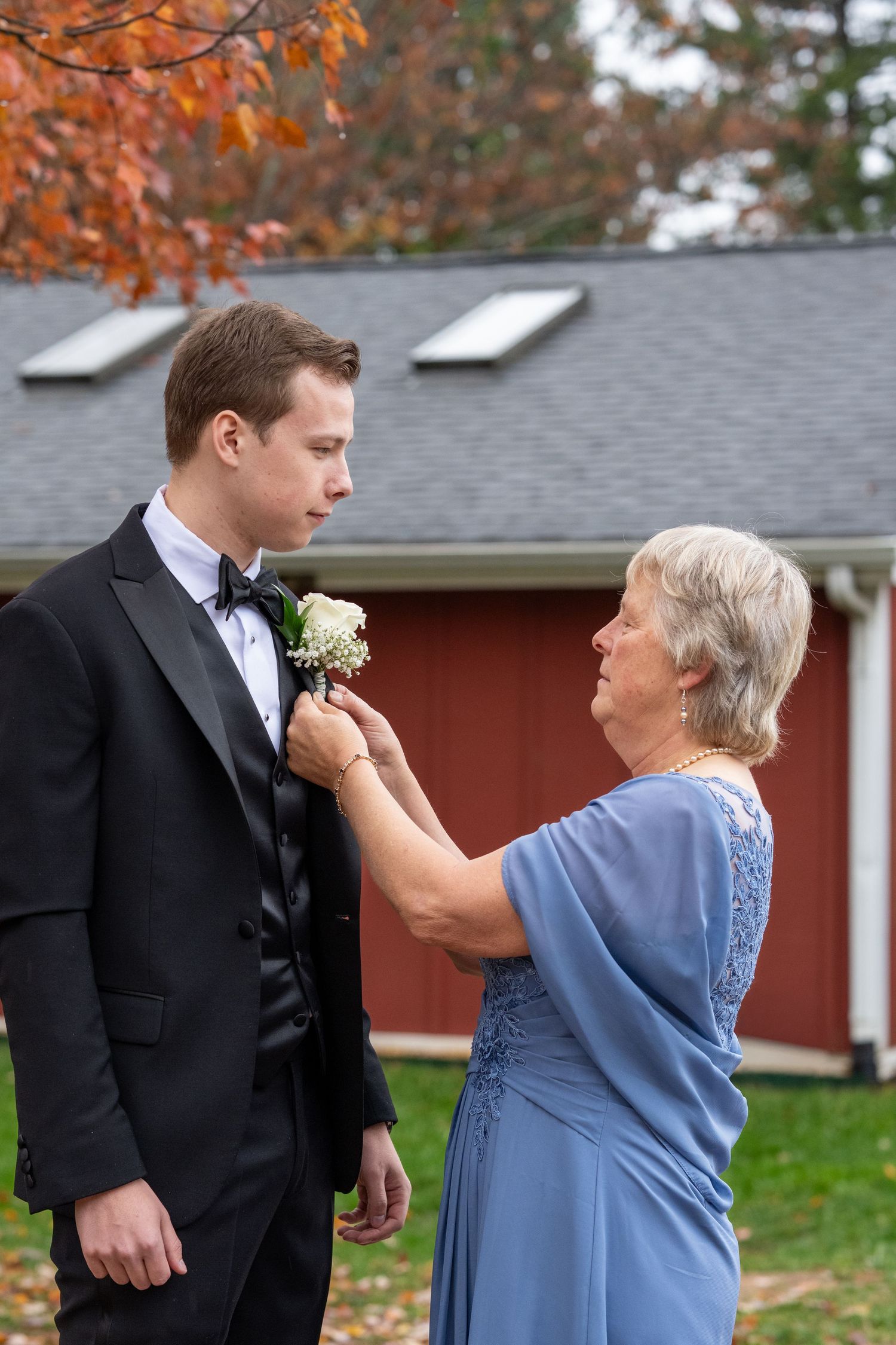Mom and Groom Mom is putting on grooms boutonniere