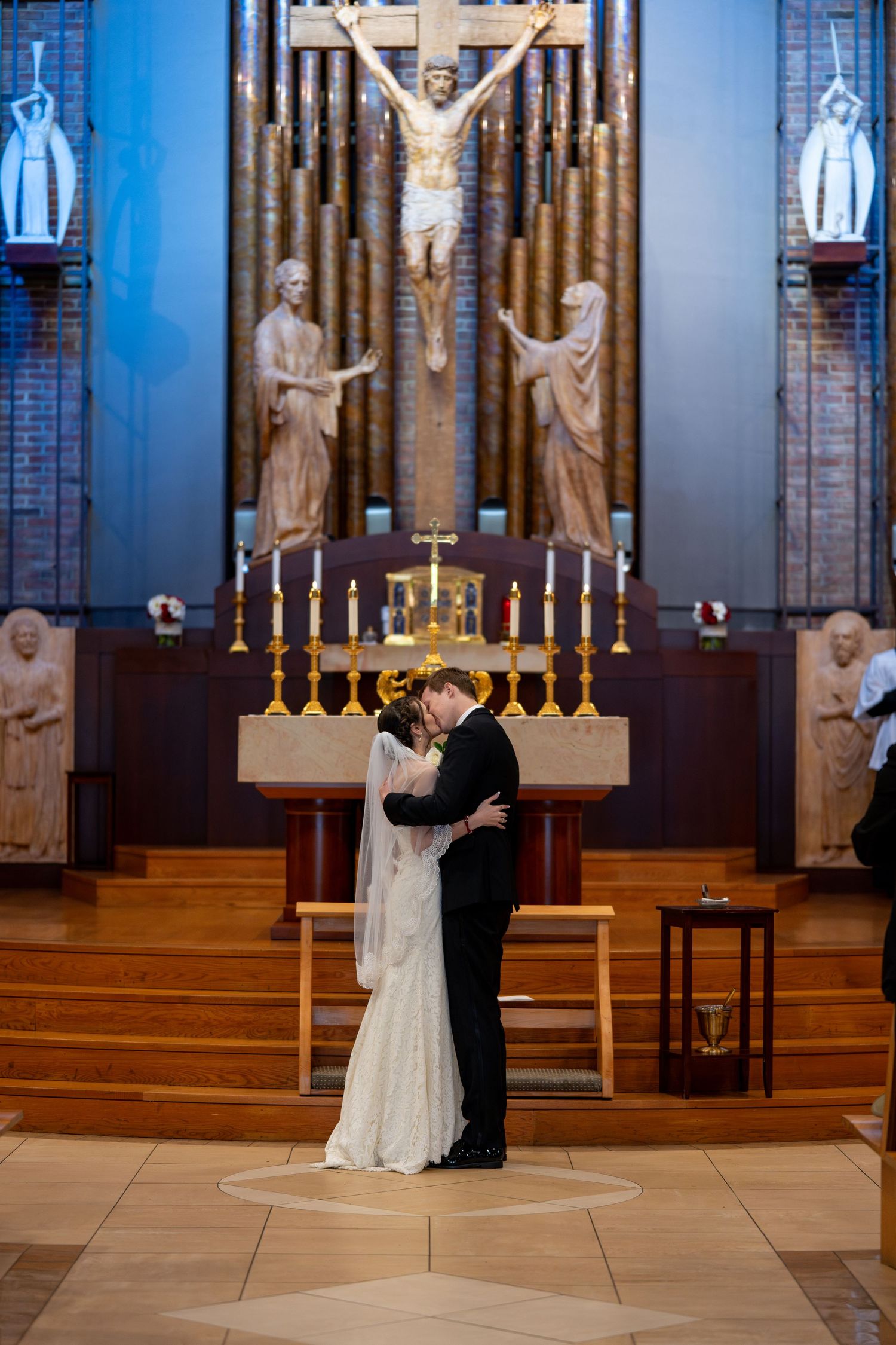 Bride and Groom First Kiss in front of altar St. Mary of the Immaculate Conception Roman Catholic Church Fredericksburg Virginia