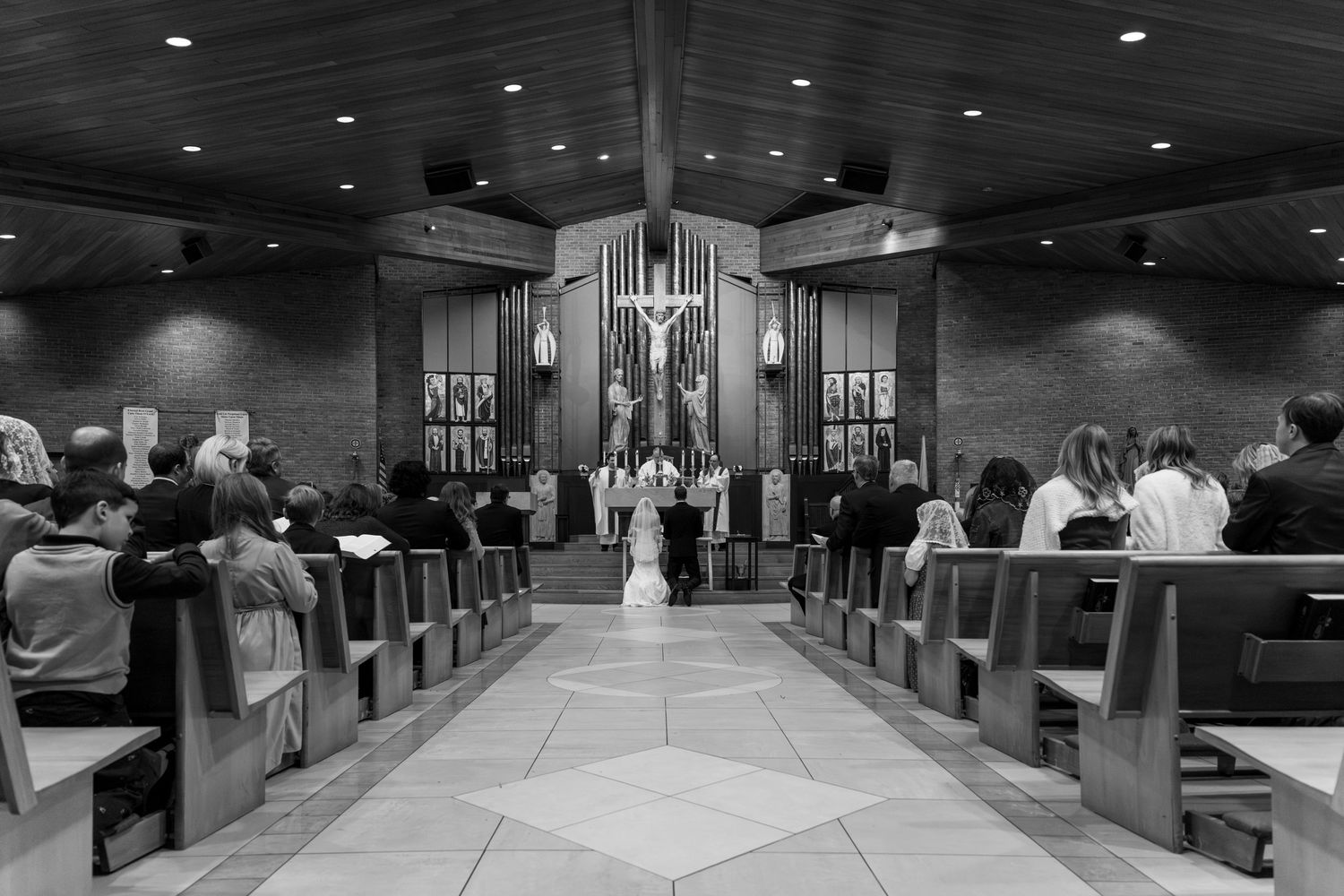 Black&white of bride&groom before alter w/ guests in pews St. Mary of the Immaculate Conception Catholic Church Fredericksburg Virginia