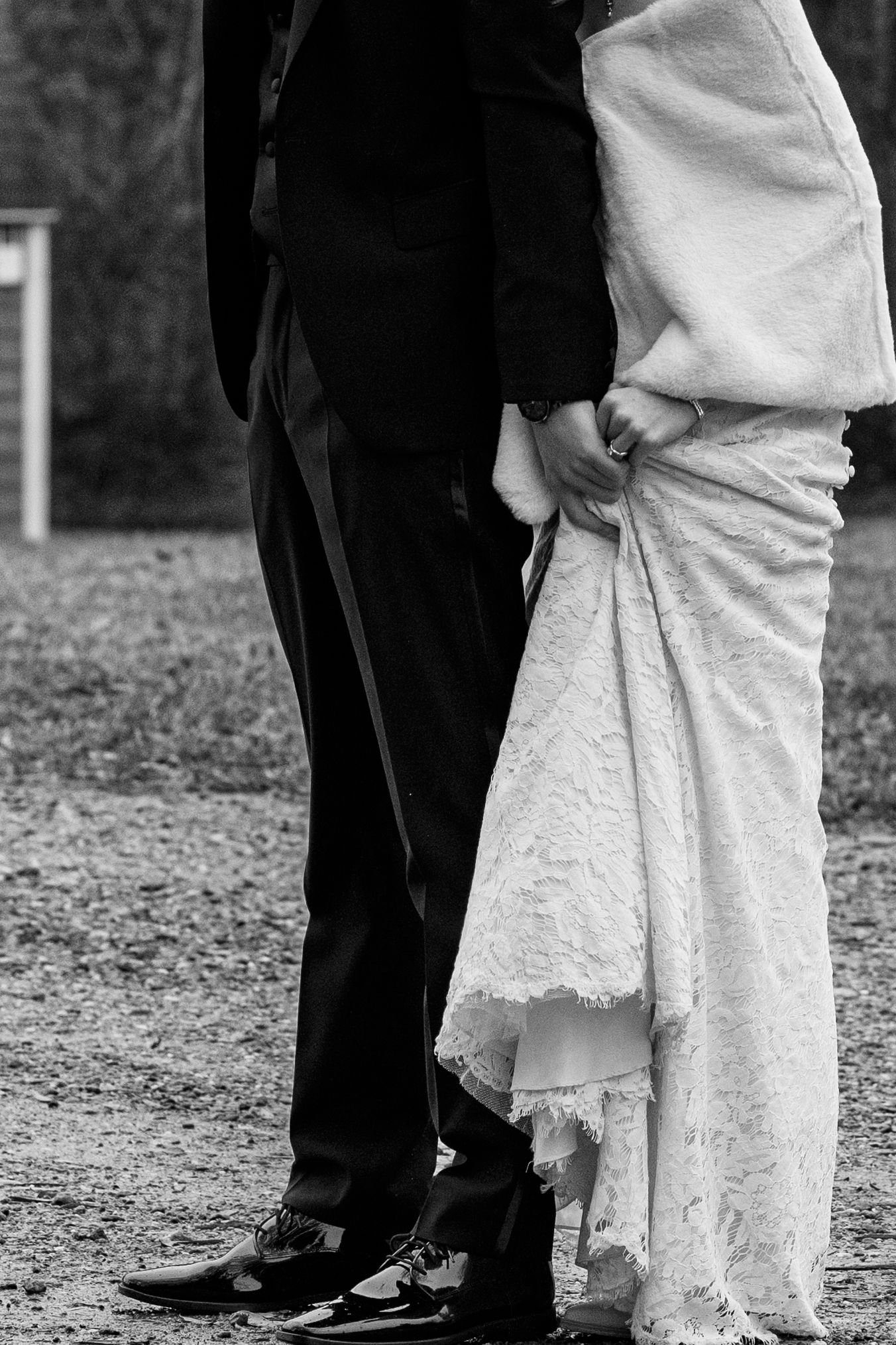Black and white close up of bride and groom holding hands while praying