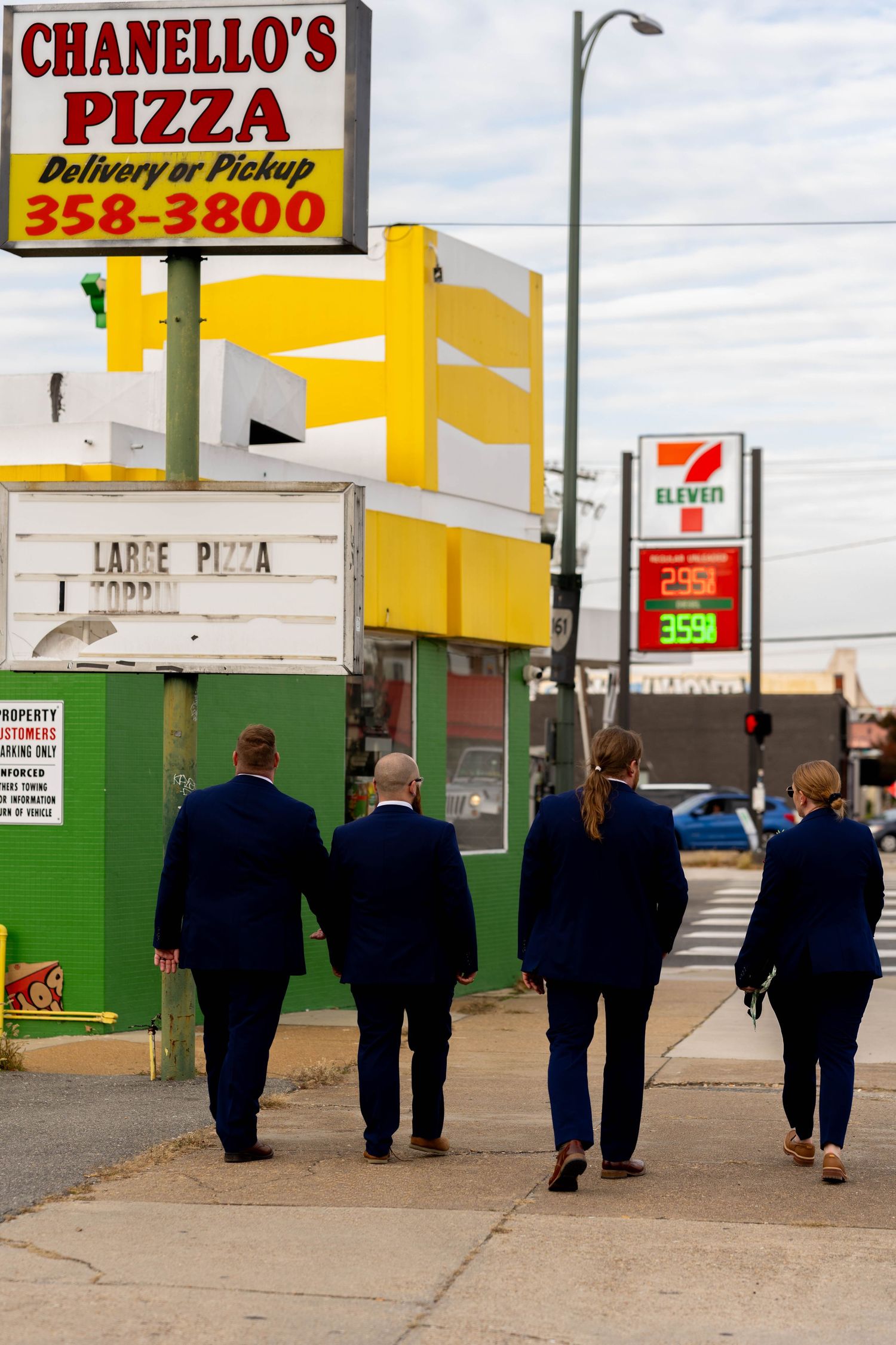 groom and groomsmen walking to the Reception past Chanello's Pizza Richmond Virginia