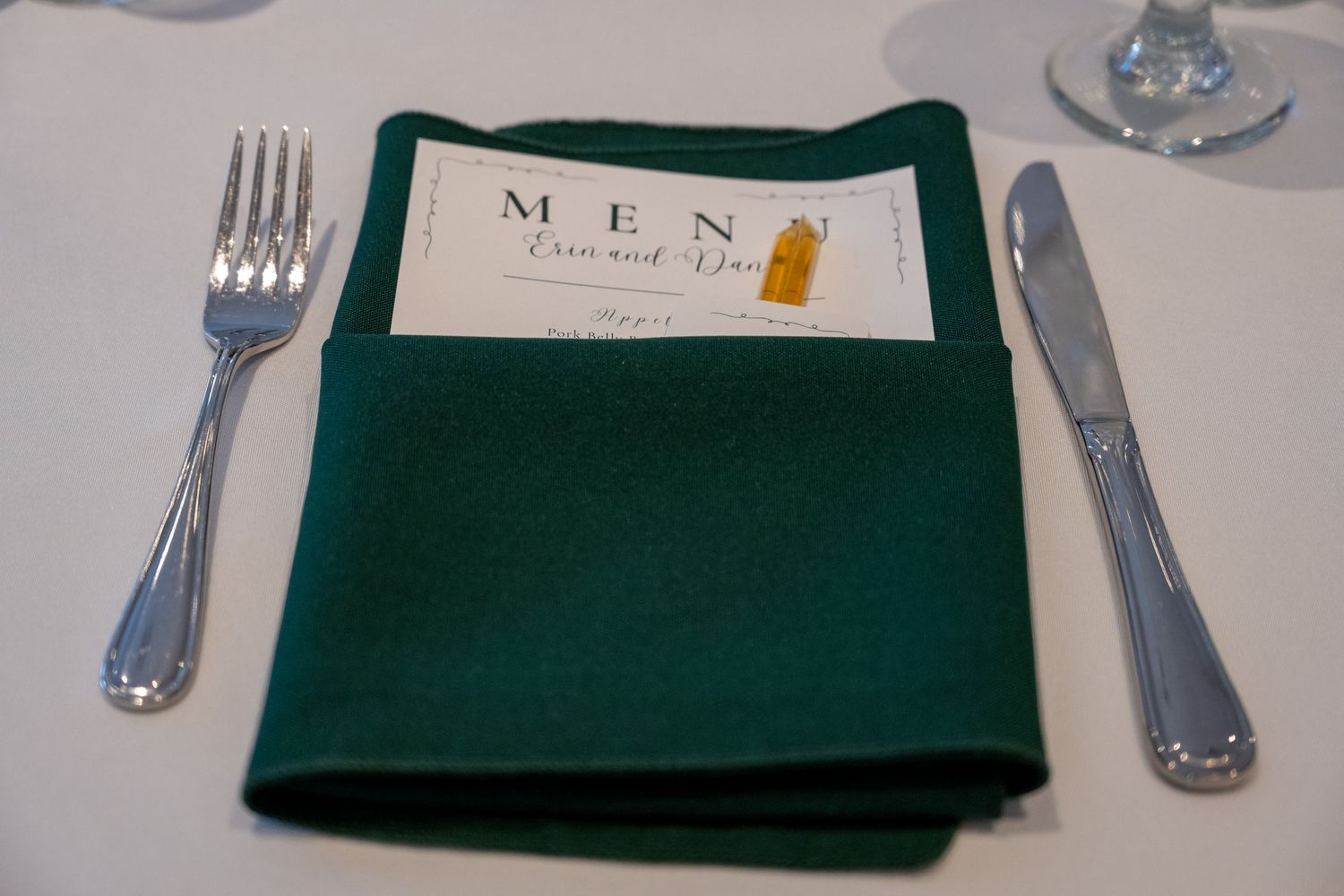 close up of table setting menu in napkin with honey stick.