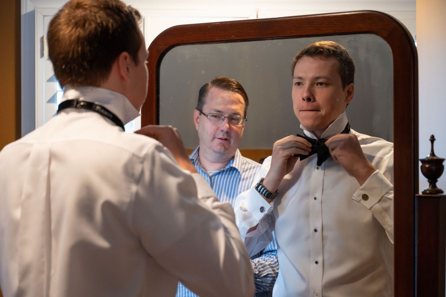 groom with father-in-law tying a bowtie.