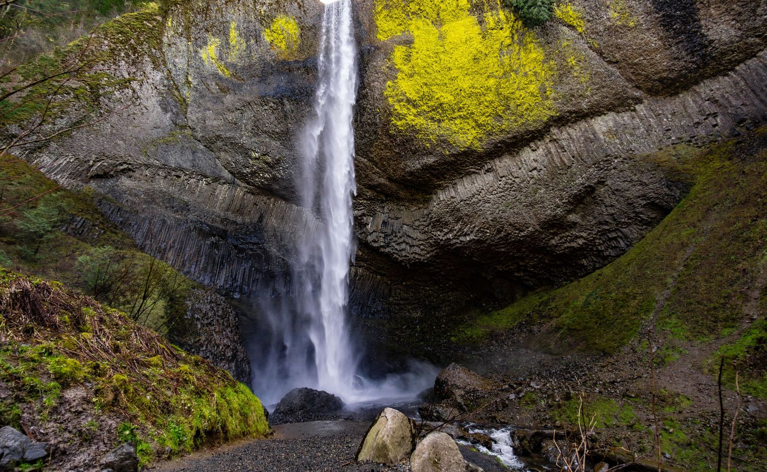 Series of waterfall views cascading down moss-covered cliffs with yellow foliage.
