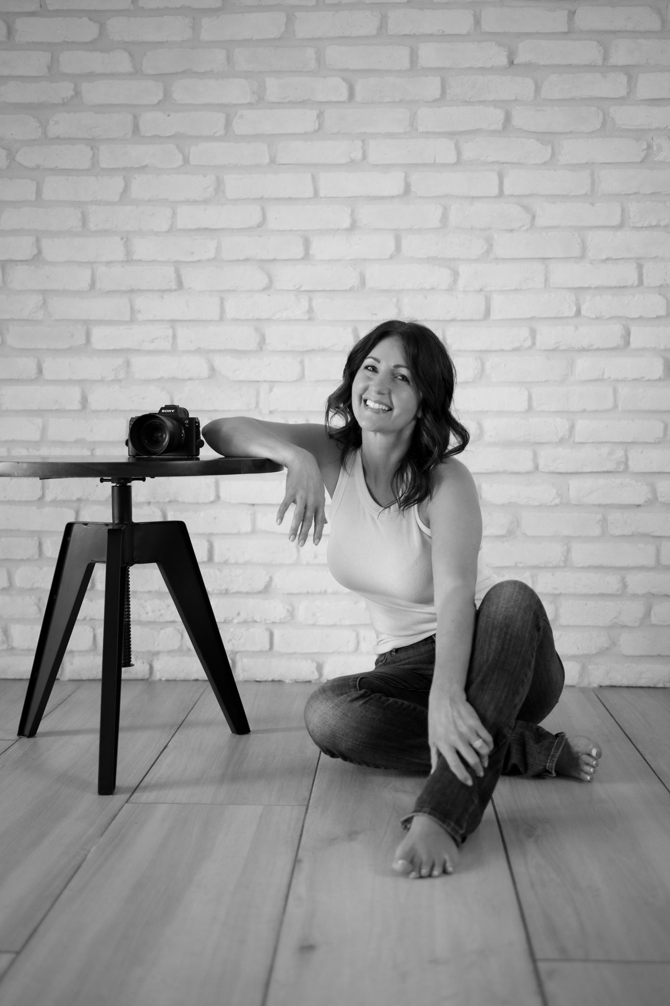 Black and white sequence showing playful interactions with a small table on wooden floor.