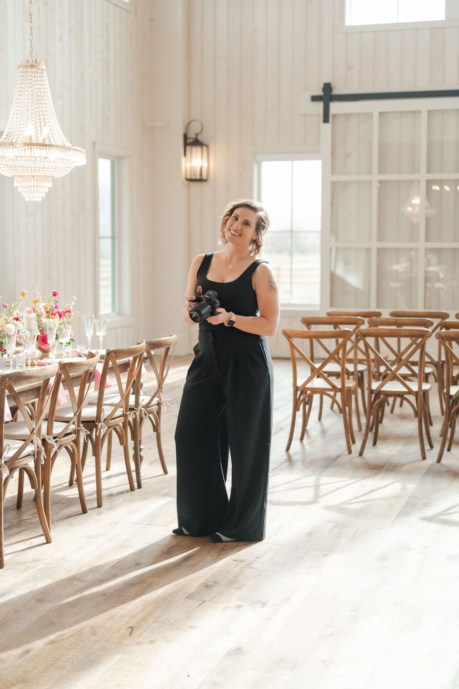 Coley Cook smiles and holds her camera at the River Bottoms Ranch venue during a Utah Park City Wedding.
